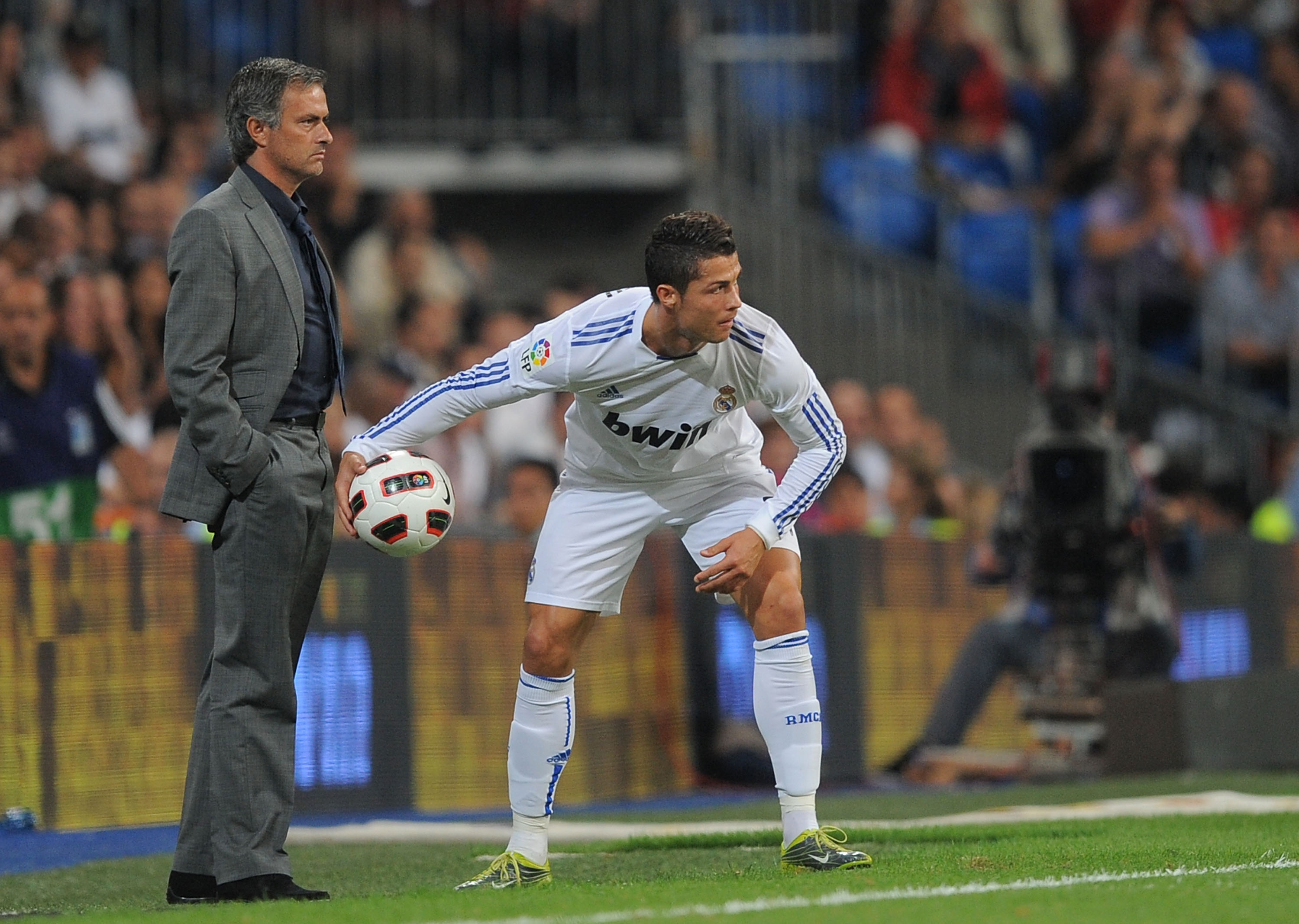 MADRID, SPAIN - SEPTEMBER 21:  Cristiano Ronaldo of Ral Madrid throws the ball back in play beside Real manager Jose Mourinho during the La Liga match between Real Madrid and Espanyol at Estadio Santiago Bernabeu on September 21, 2010 in Madrid, Spain.  (