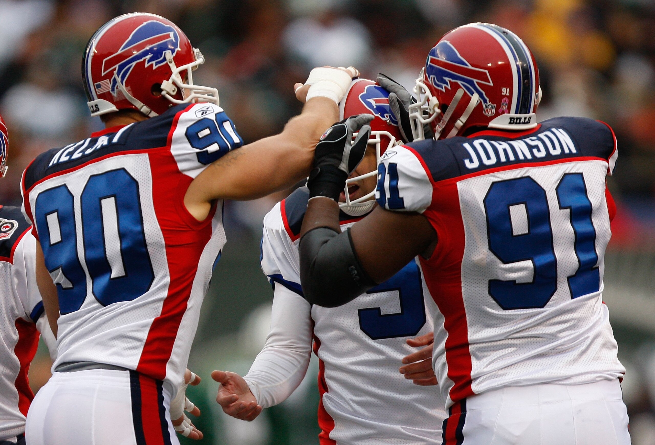 EAST RUTHERFORD, NJ - OCTOBER 18: Rian Lindell #9 of the Buffalo Bills is congratulated by teammates Chris Kelsay #90 and Spencer Johnson #91 after kicking a field goal against the New York Jets during the game on October 18, 2009 at Giants Stadium in Eas