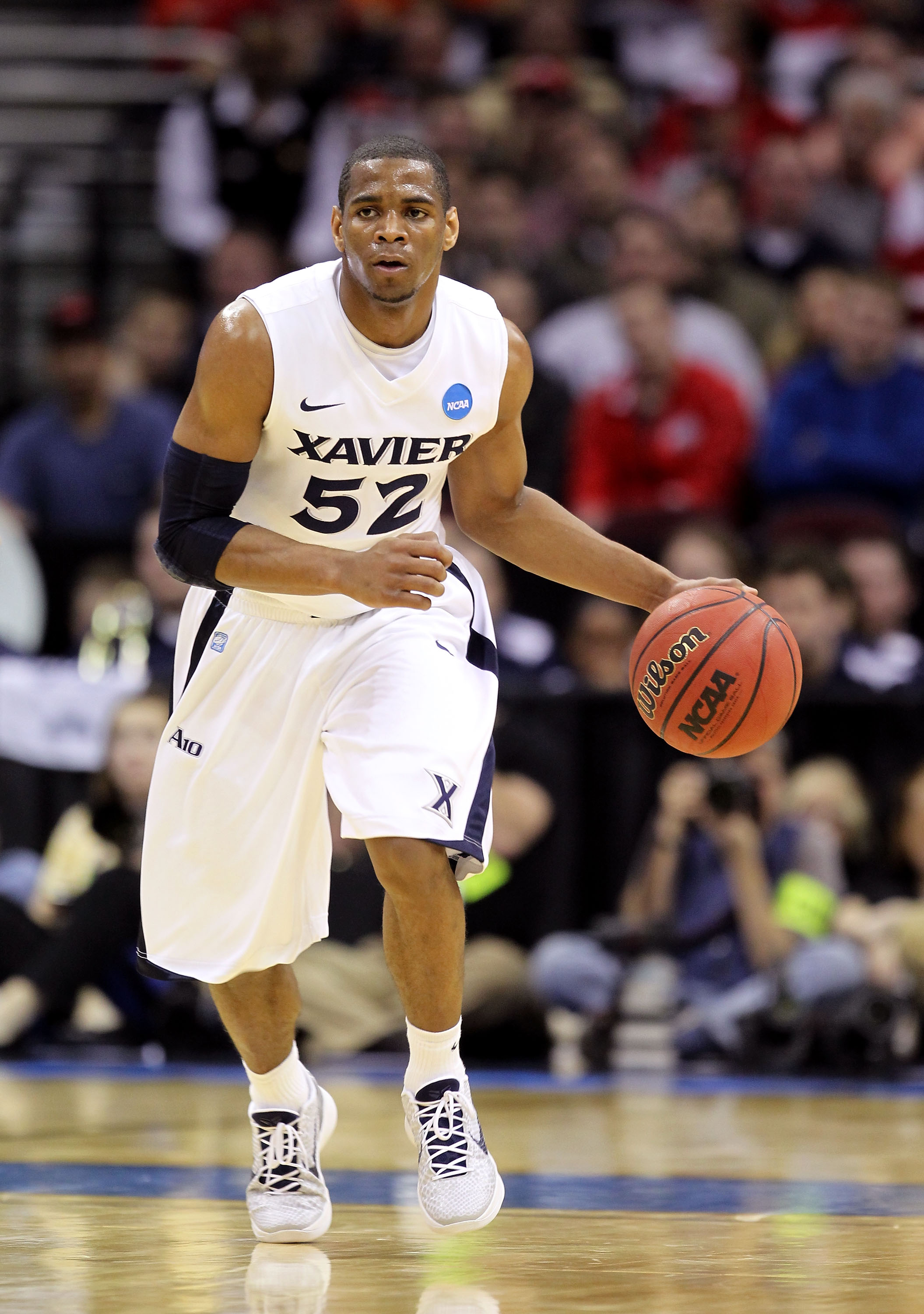 CLEVELAND, OH - MARCH 18: Tu Holloway #52 of the Xavier Musketeers handles the ball against the Marquette Golden Eagles during the second round of the 2011 NCAA men's basketball tournament at Quicken Loans Arena on March 18, 2011 in Cleveland, Ohio. (Pho