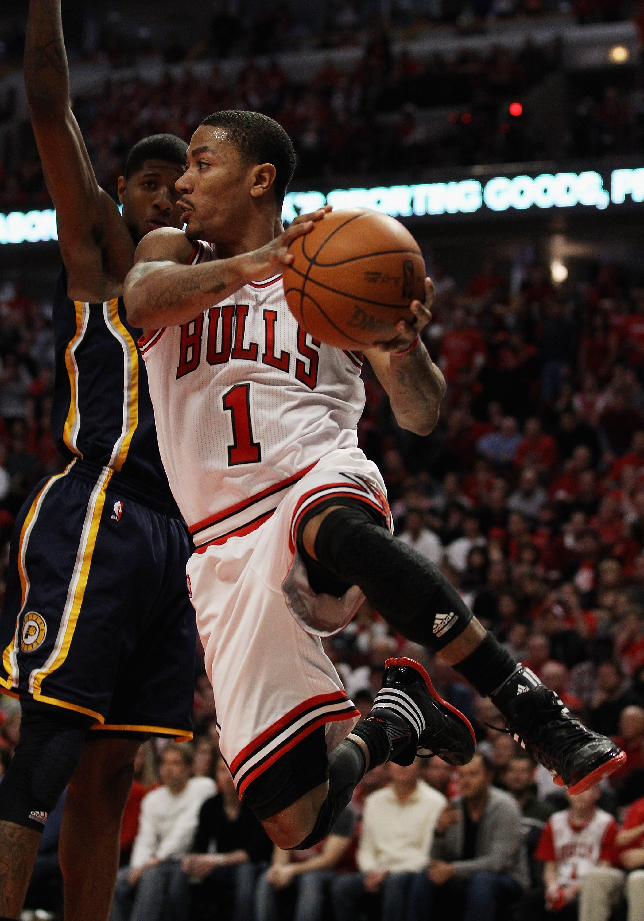 CHICAGO, IL - APRIL 16: Derrick Rose #1 of the Chicago Bulls leaps to pass the ball around Paul George #24 of the Indiana Pacers in Game One of the Eastern Conference Quarterfinals in the 2011 NBA Playoffs at the United Center on April 16, 2011 in Chicago