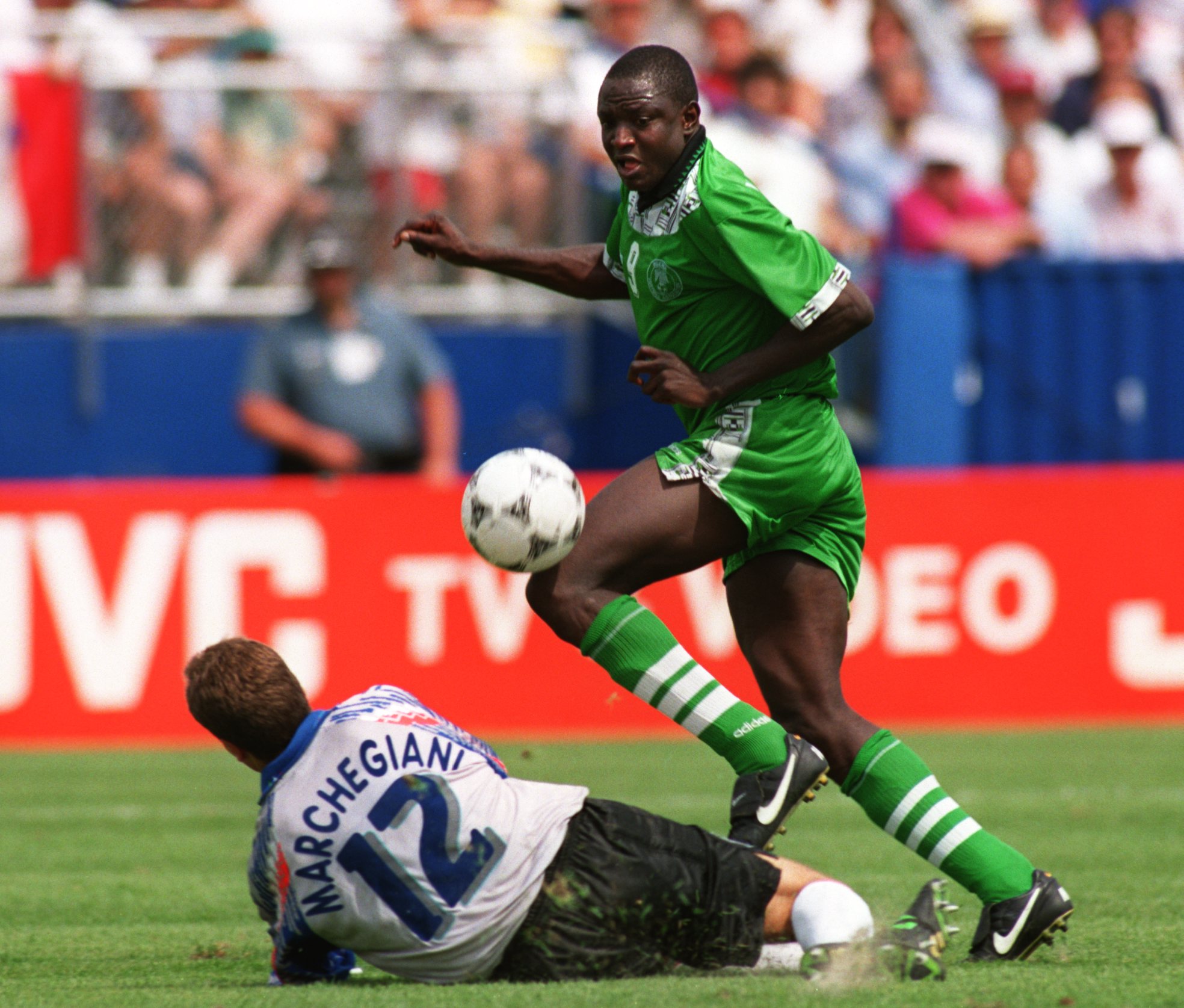 5 JULY 1994:  RASHEED YEKINI OF NIGERIA DRIBBLES AROUND THE FALLEN LUCA MARCHESIANI OF ITALY DURING THEIR SECOND ROUND MATCH IN THE 1994 WORLD CUP AT FOXBORO STADIUM IN MASSACHUSETTS.  ITALY WON THE GAME, 2-1, IN EXTRA TIME. Mandatory Credit: Shaun Botter