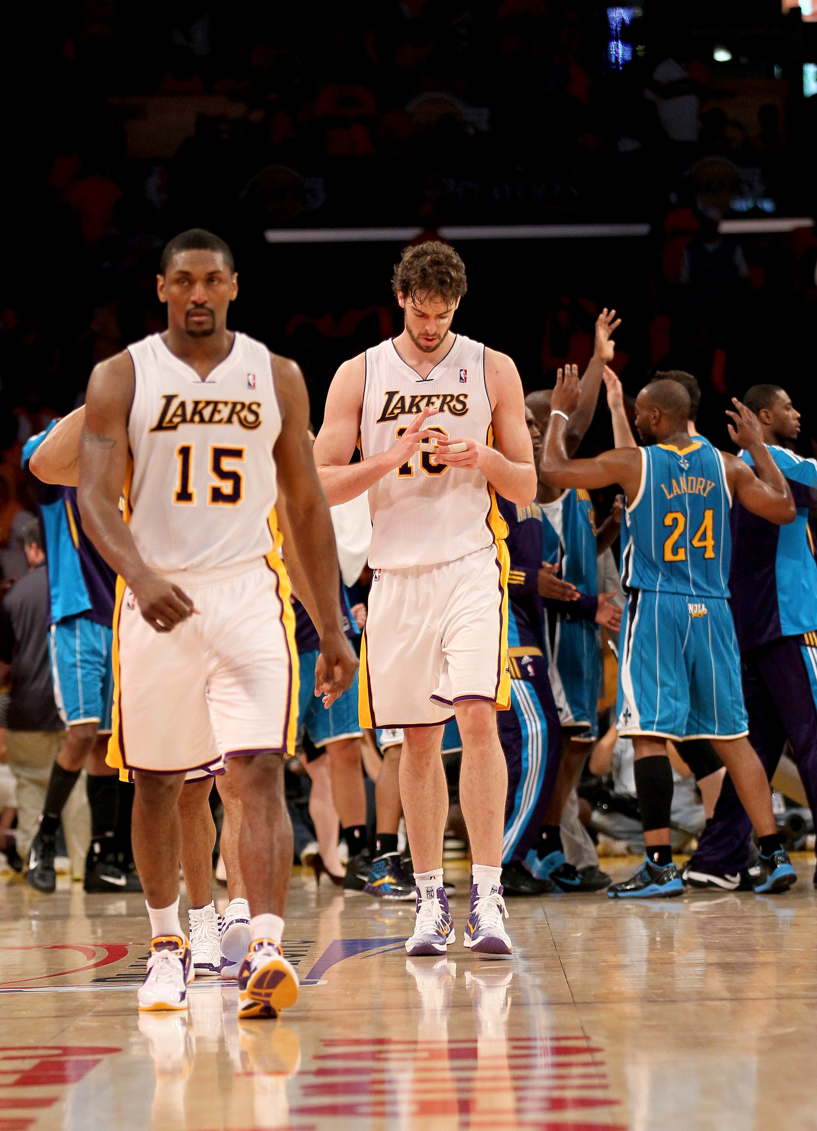 LOS ANGELES, CA - APRIL 17: Pau Gasol #16 and Ron Artest of the Los Angeles Lakers walk off the court as the New Orleans Hornets celebrate after Game One of the Western Conference Quarterfinals in the 2011 NBA Playoffs on April 17, 2011 at Staples Center