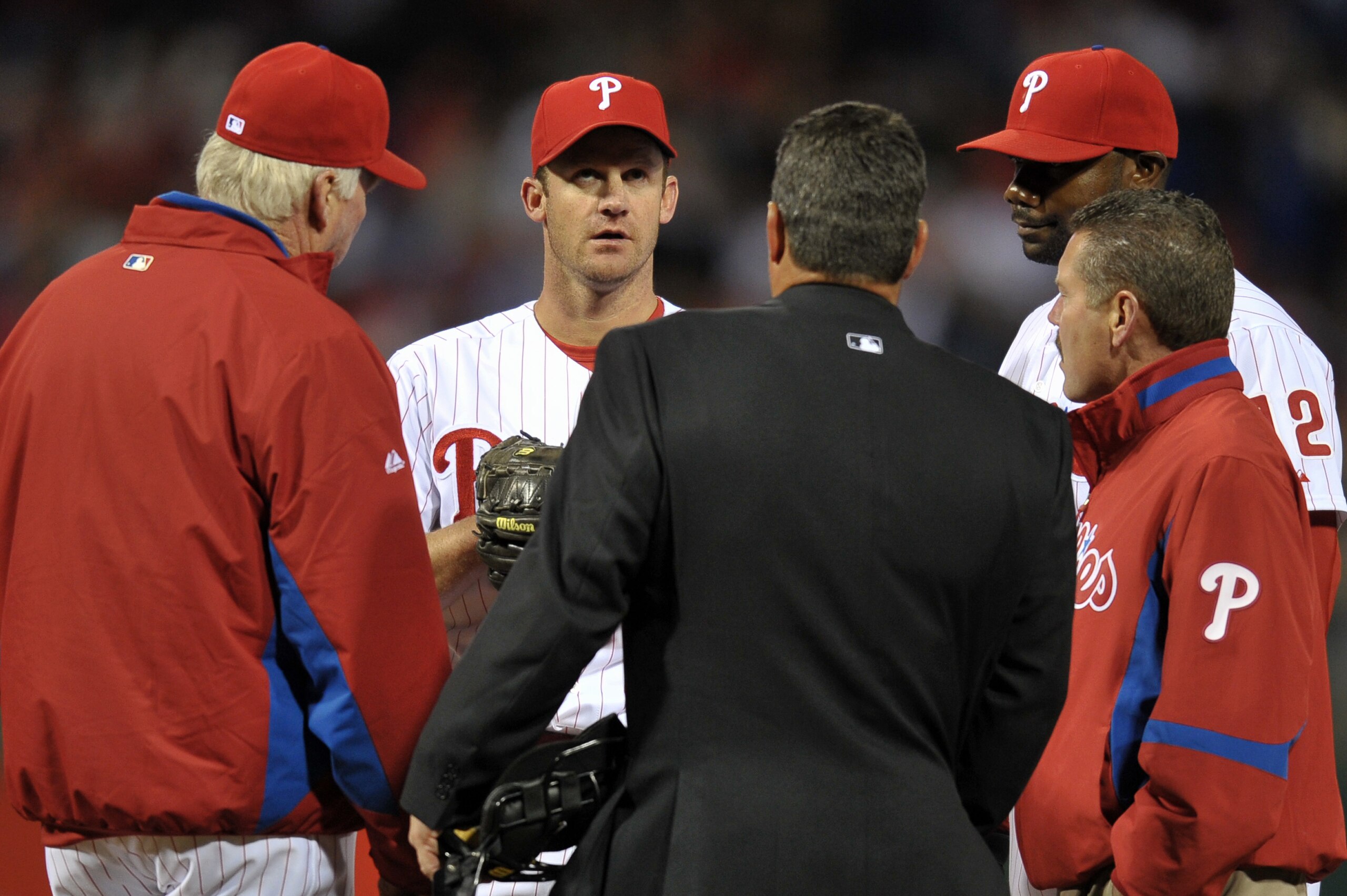 PHILADELPHIA, PA - APRIL 15: Starting pitcher Roy Oswalt #44 of the Philadelphia Phillies meets on the mound with manager Charlie Manuel, home plate umpire Rob Drake, Ryan Howard #6 and a trainer about an injury he suffered during the game against the Flo PHILADELPHIA, PA - APRIL 15: Starting pitcher Roy Oswalt #44 of the Philadelphia Phillies meets on the mound with manager Charlie Manuel, home plate umpire Rob Drake, Ryan Howard #6 and a trainer about an injury he suffered during the game against the Flo