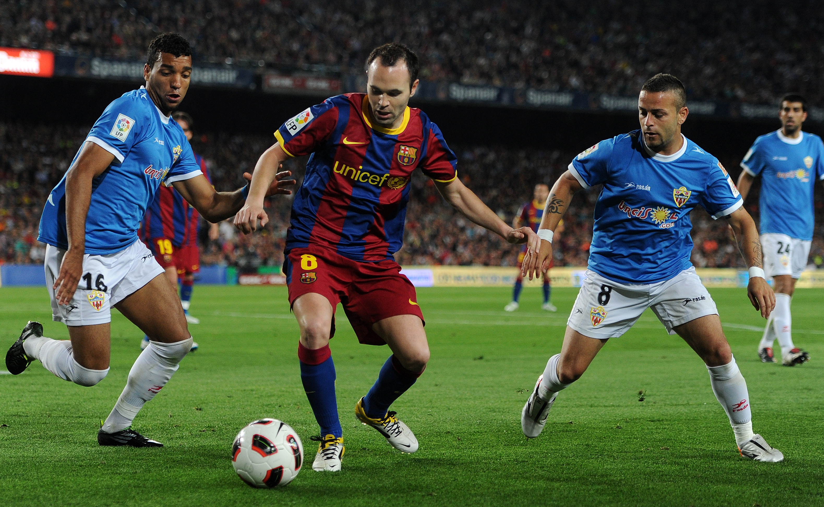 BARCELONA, SPAIN - APRIL 09:  Andres Iniesta (C) of Barcelona duels for the ball with Michel Macedo (L) and Albert Crusat Domene of Almeria during the la Liga match between FC Barcelona and UD Almeria at the Camp Nou stadium on April 9, 2011 in Barcelona,