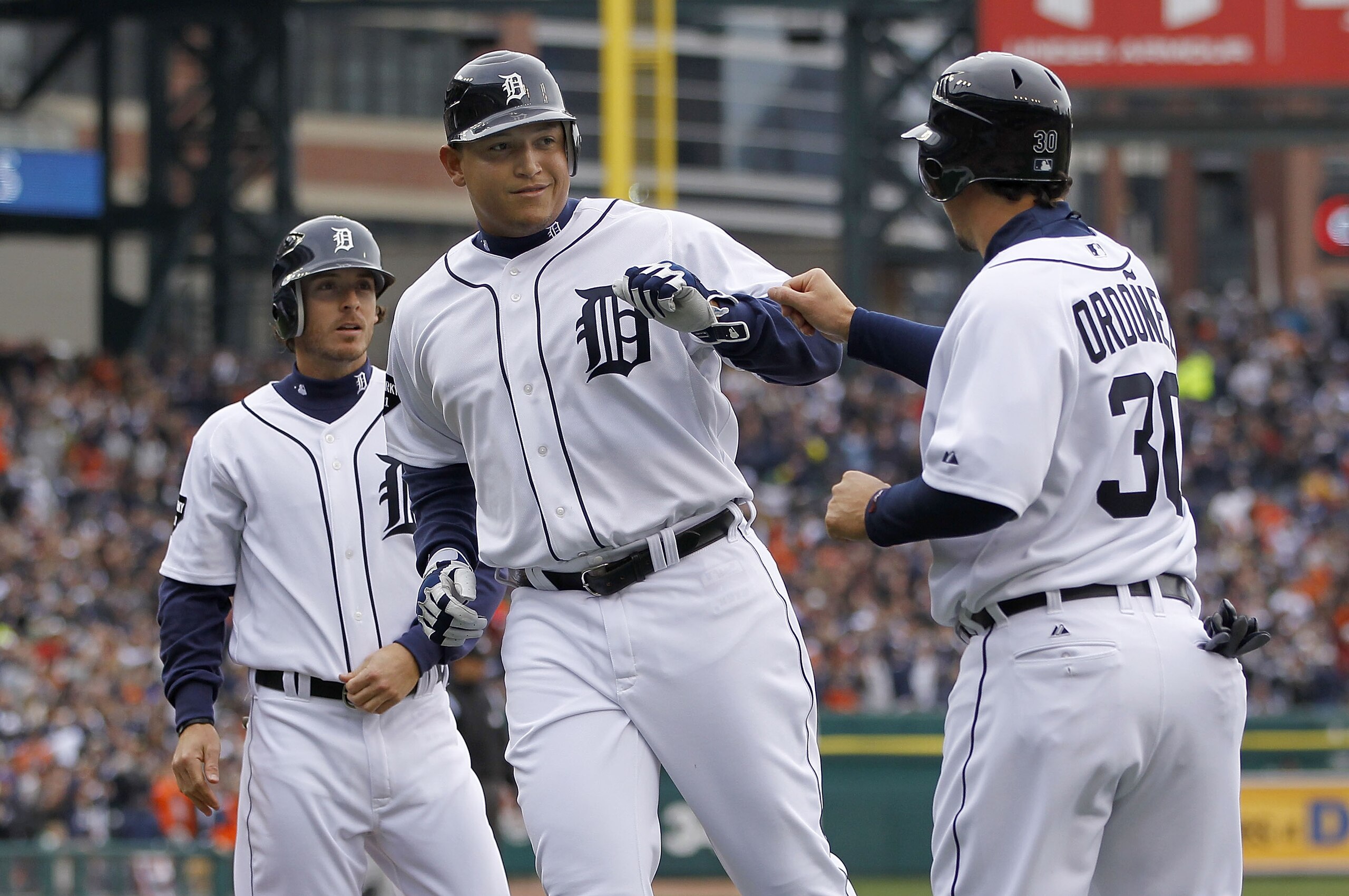 DETROIT, MI - APRIL 08:  Miguel Cabrera #24 of the Detroit Tigers celebrates at home plate after scoring on a Victor Martinez RBI double with Magglio Ordonez #30 and Will Rhymes #28 while playing the Kansas City Royals on Opening Day at Comerica Park on A