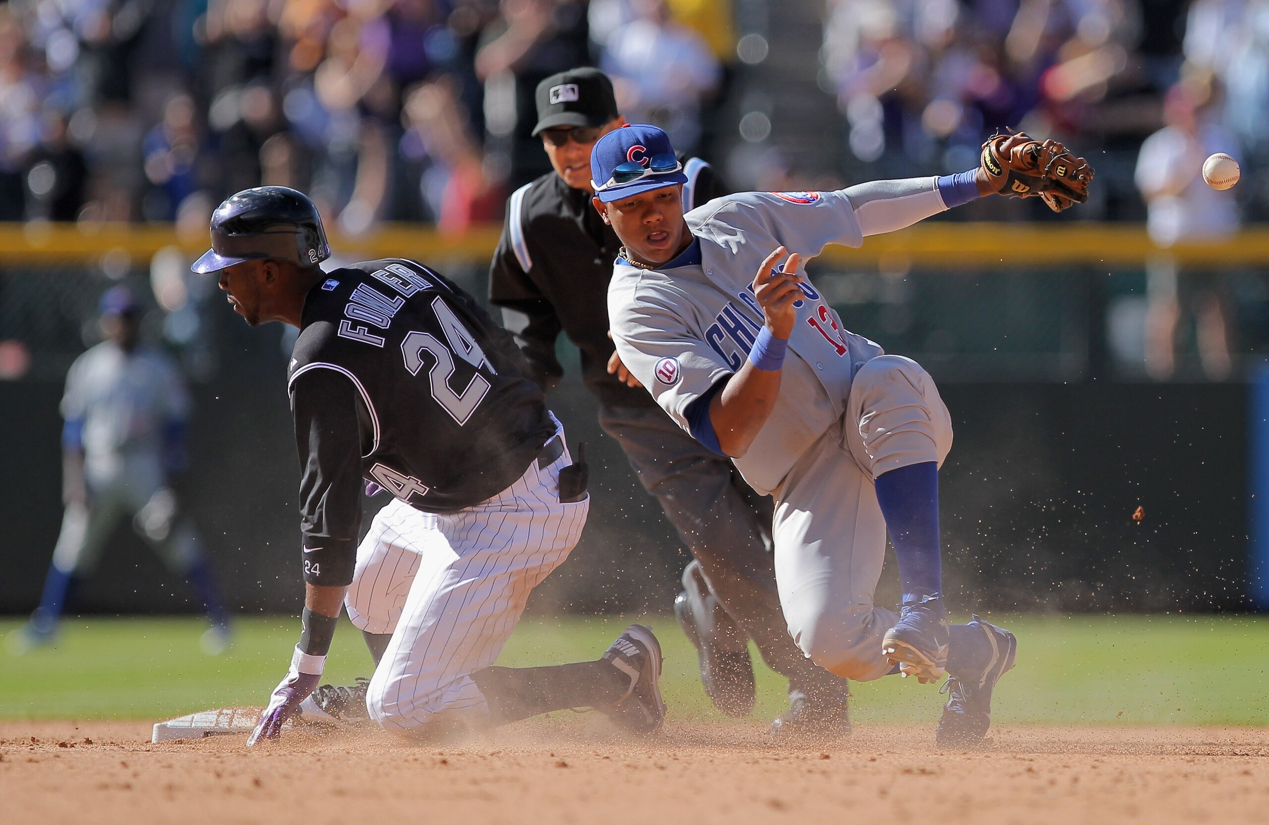 DENVER, CO - APRIL 17:  Dexter Fowler #24 of the Colorado Rockies slides into second safely with the game winning hit as shortstop Starlin Castro #13 of the Chicago Cubs takes the late throw from right fielder Kosuke Fukudome of the Cubs in the eighth inn