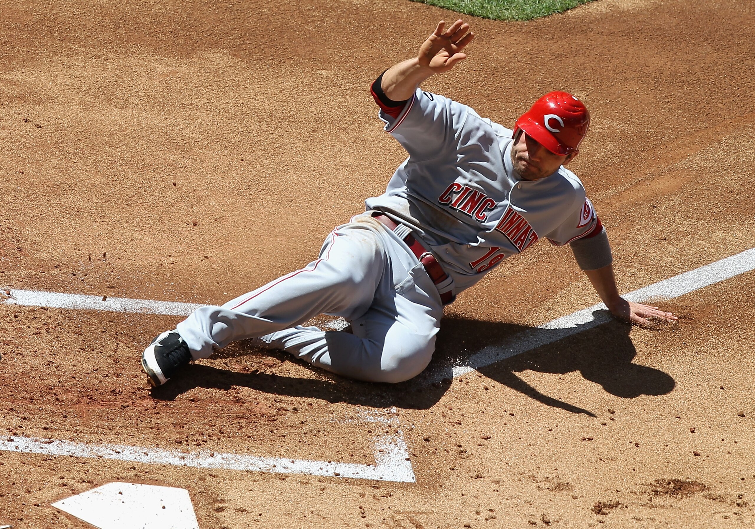 PHOENIX, AZ - APRIL 10:  Joey Votto #19 of the Cincinnati Reds slides in to score a first inning run against the Arizona Diamondbacks during the Major League Baseball game at Chase Field on April 10, 2011 in Phoenix, Arizona.  (Photo by Christian Petersen