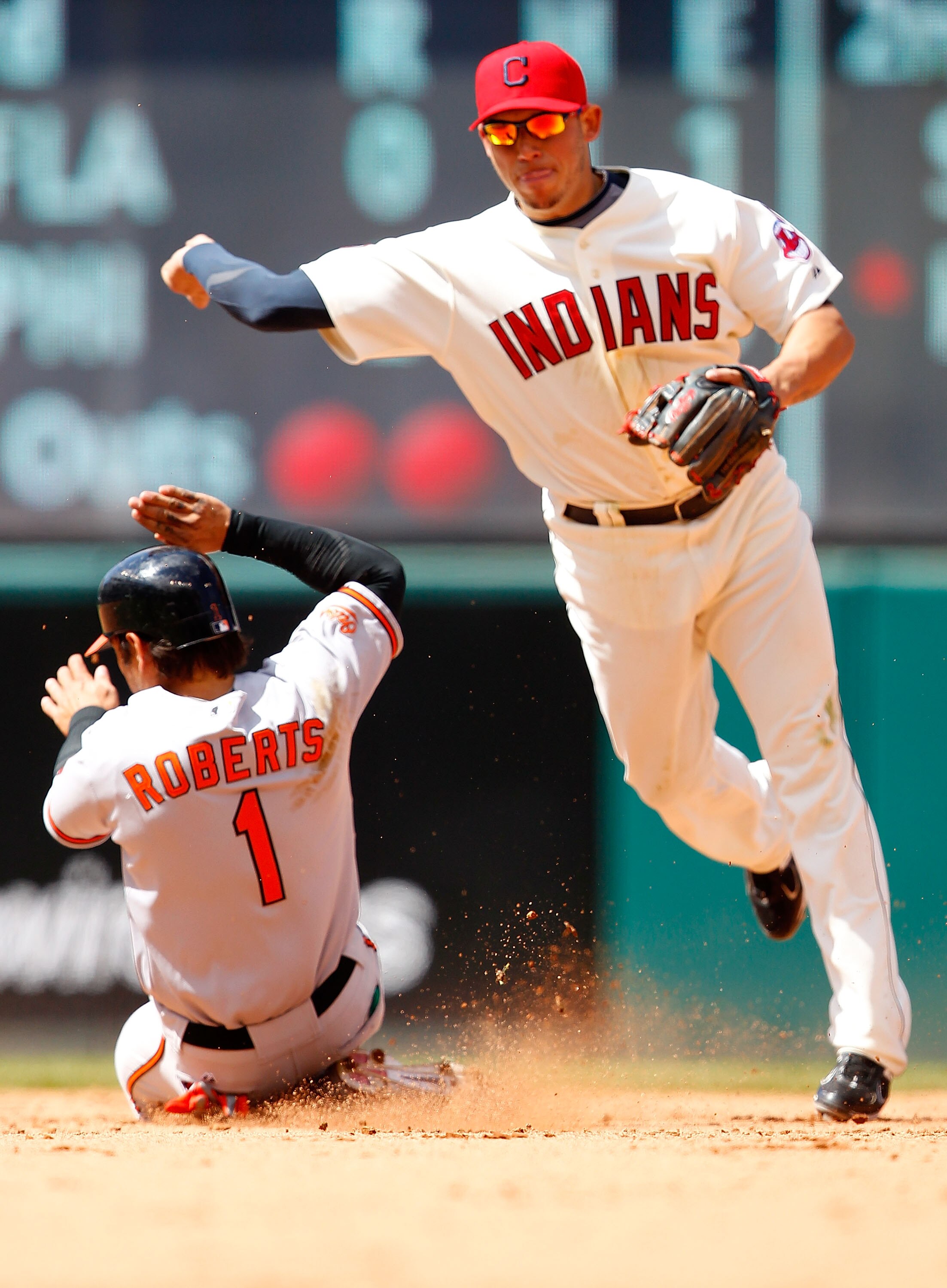 CLEVELAND - APRIL 17:  Orlando Cabrera #20 of the Cleveland Indians turns the double play on Brian Roberts #1 of the Baltimore Orioles during the game on April 17, 2011 at Progressive Field in Cleveland, Ohio.  (Photo by Jared Wickerham/Getty Images)
