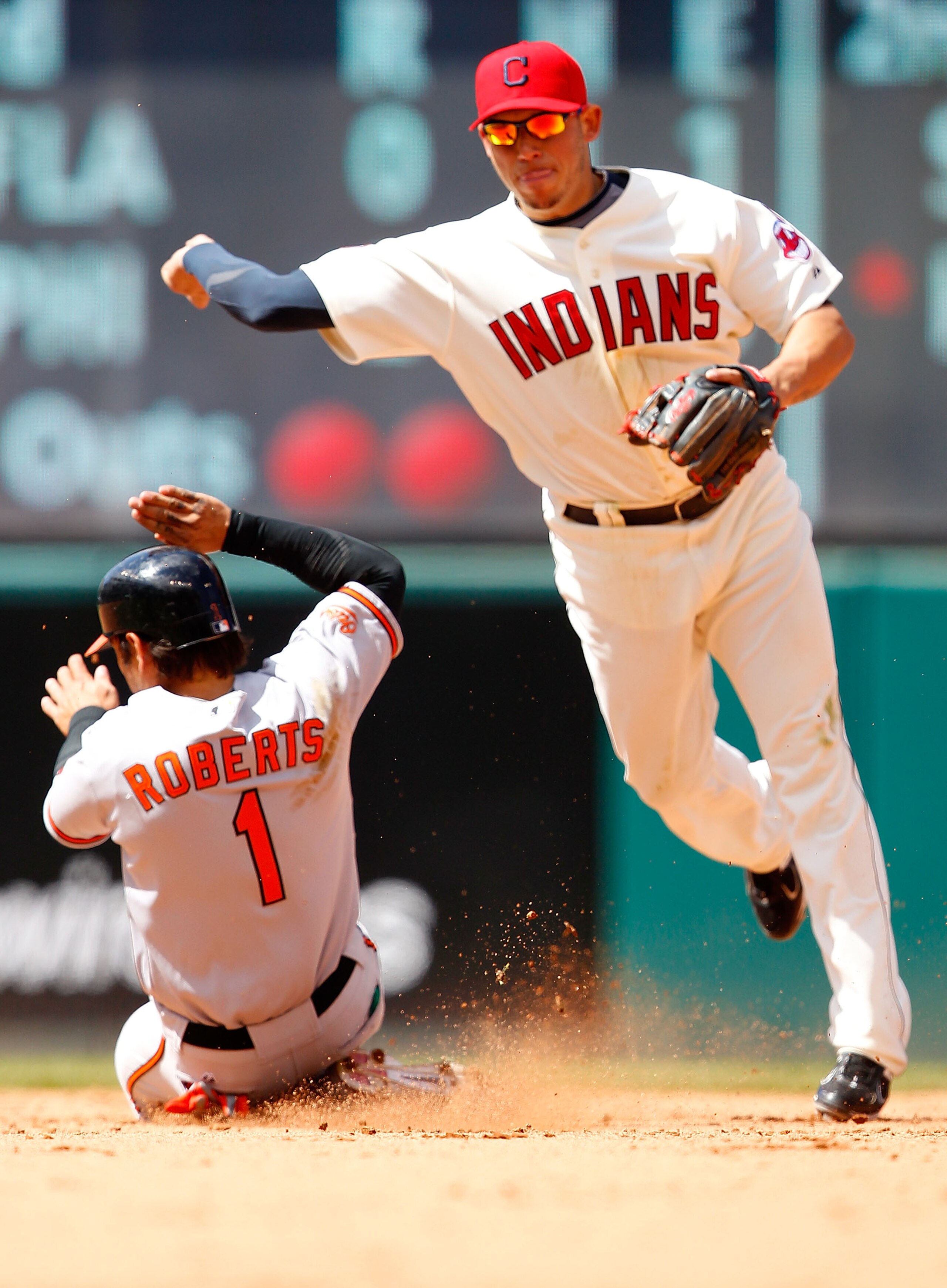 CLEVELAND - APRIL 17:  Orlando Cabrera #20 of the Cleveland Indians turns the double play on Brian Roberts #1 of the Baltimore Orioles during the game on April 17, 2011 at Progressive Field in Cleveland, Ohio.  (Photo by Jared Wickerham/Getty Images)