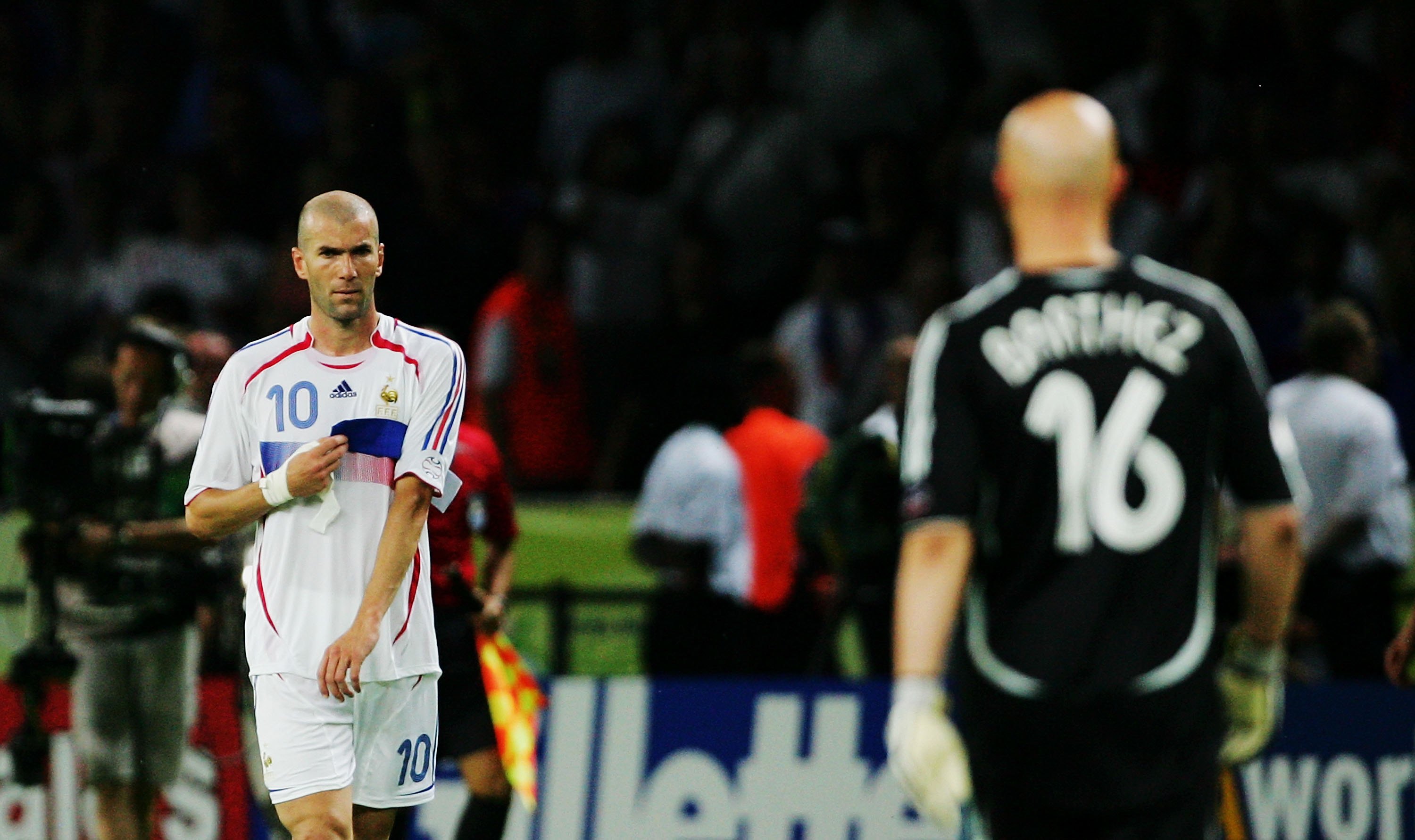 BERLIN - JULY 09:  Zinedine Zidane of France removes his captain's armband to pass to Fabien Barthez after being sent off during the FIFA World Cup Germany 2006 Final match between Italy and France at the Olympic Stadium on July 9, 2006 in Berlin, Germany