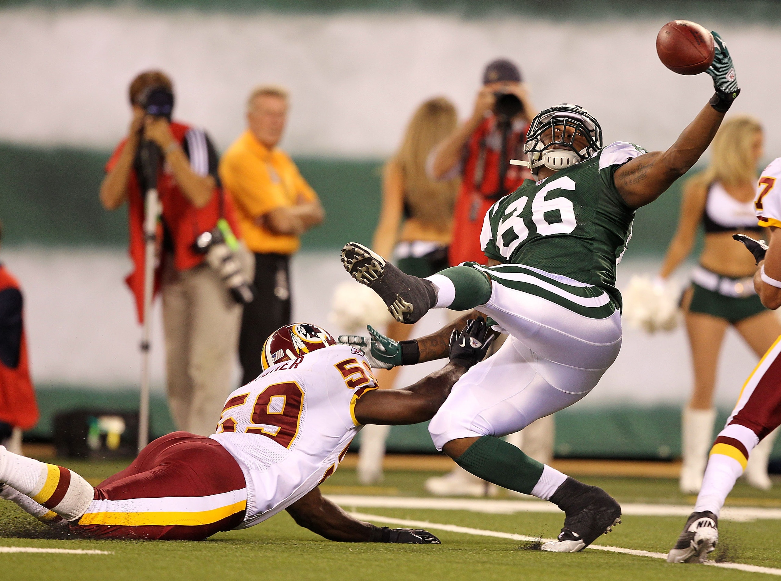 EAST RUTHERFORD, NJ - AUGUST 27: Jeff Cumberland #86 of the New York Jets cannot hang onto the ball as London Fletcher #59 of the Washington Redskins defends during their preseason game on August 27, 2010 at the New Meadowlands Stadium in East Rutherfo EAST RUTHERFORD, NJ - AUGUST 27: Jeff Cumberland #86 of the New York Jets cannot hang onto the ball as London Fletcher #59 of the Washington Redskins defends during their preseason game on August 27, 2010 at the New Meadowlands Stadium in East Rutherfo
