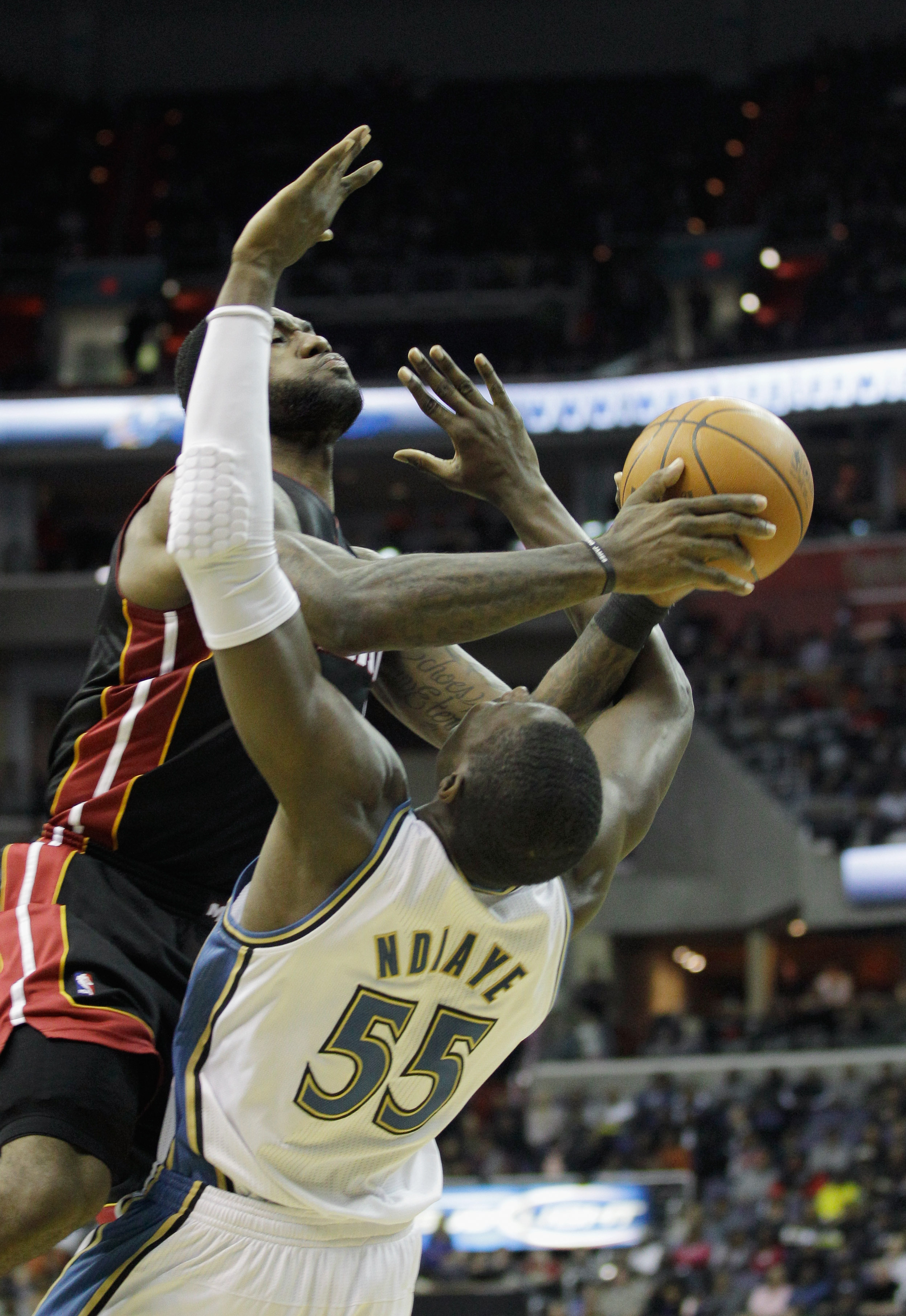 WASHINGTON, DC - MARCH 30:  LeBron James #6 of the Miami Heat is fouled by Hamady Ndiaye #55 of the Washington Wizards during the first half at the Verizon Center on March 30, 2011 in Washington, DC. NOTE TO USER: User expressly acknowledges and agrees th