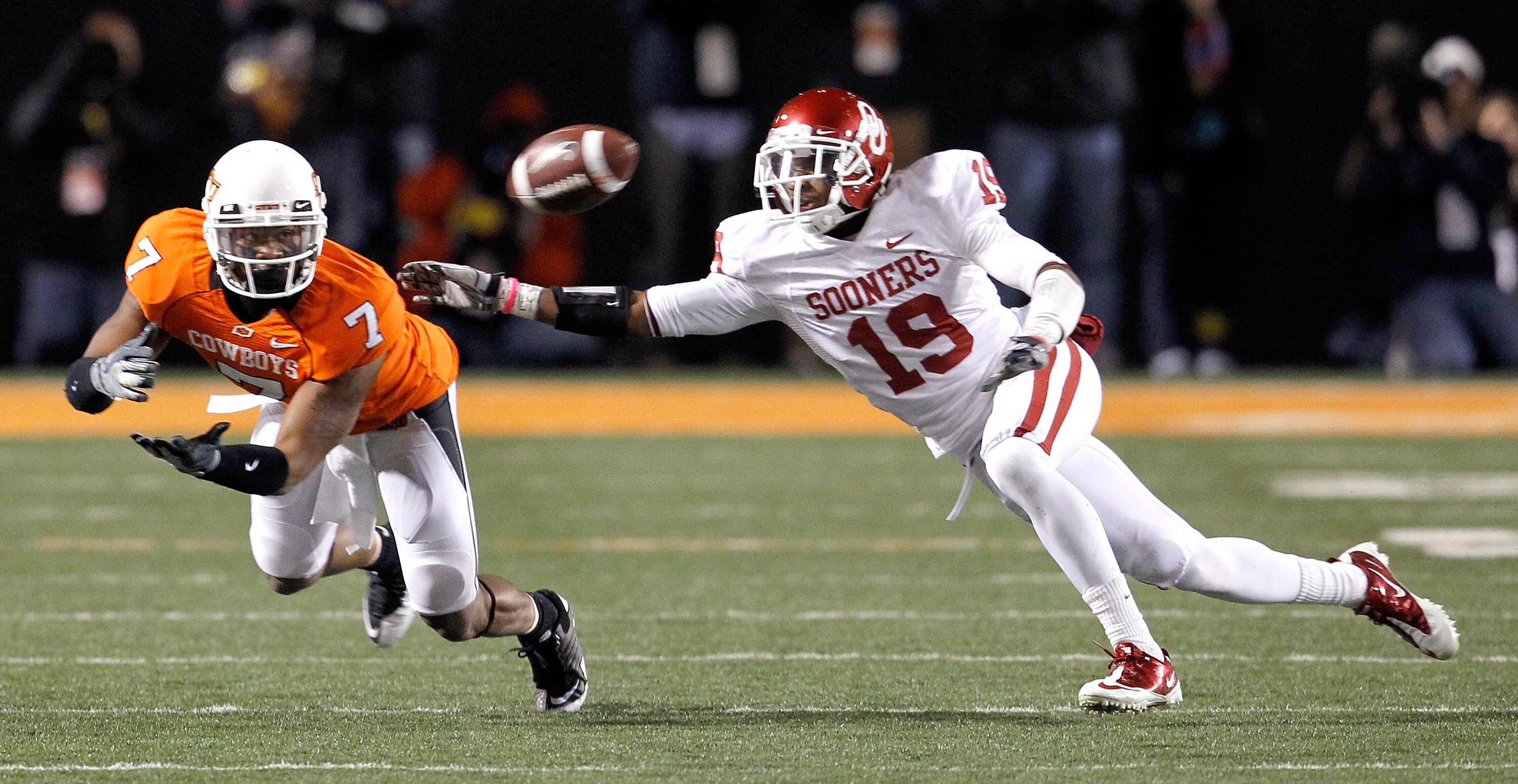 STILLWATER, OK - NOVEMBER 27:  Receiver Michael Harrison #7 of the Oklahoma State Cowboys pulls in a pass against defensive back Demontre Hurst #19 of the Oklahoma Sooners at Boone Pickens Stadium on November 27, 2010 in Stillwater, Oklahoma.  The Sooners
