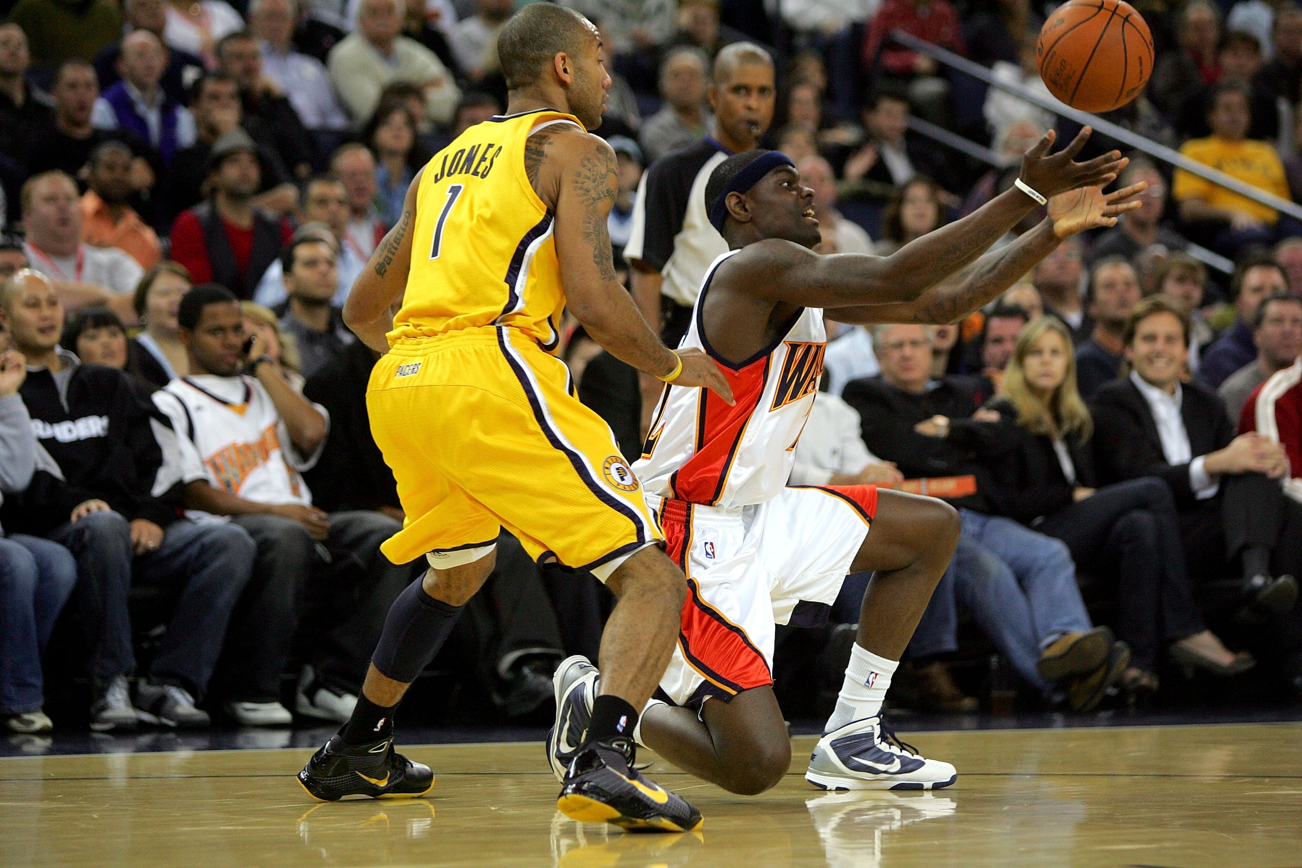 OAKLAND, CA - NOVEMBER 30:  Anthony Morrow #22 of the Golden State Warriors passes the ball from his knees while defended by Dahntay Jones #1 of the Indiana Pacers at Oracle Arena on November 30, 2009 in Oakland, California.  NOTE TO USER: User expressly