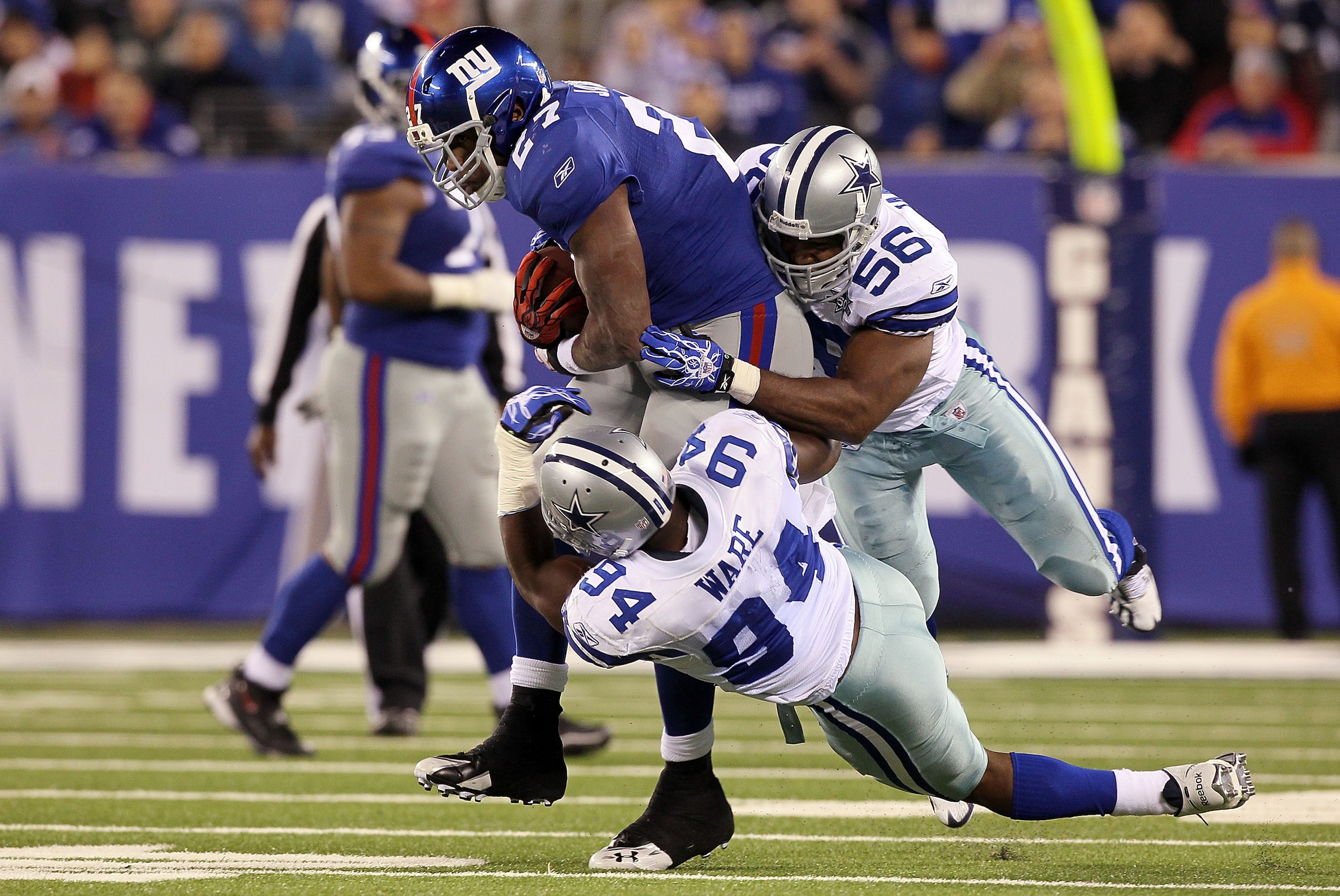 EAST RUTHERFORD, NJ - NOVEMBER 14: Bradie James #56 and DeMarcus Ware #94 of the Dallas Cowboys combine to stop a run by Brandon Jacobs #27 of the New York Giants on November 14, 2010 at the New Meadowlands Stadium in East Rutherford, New Jersey. The Cowb