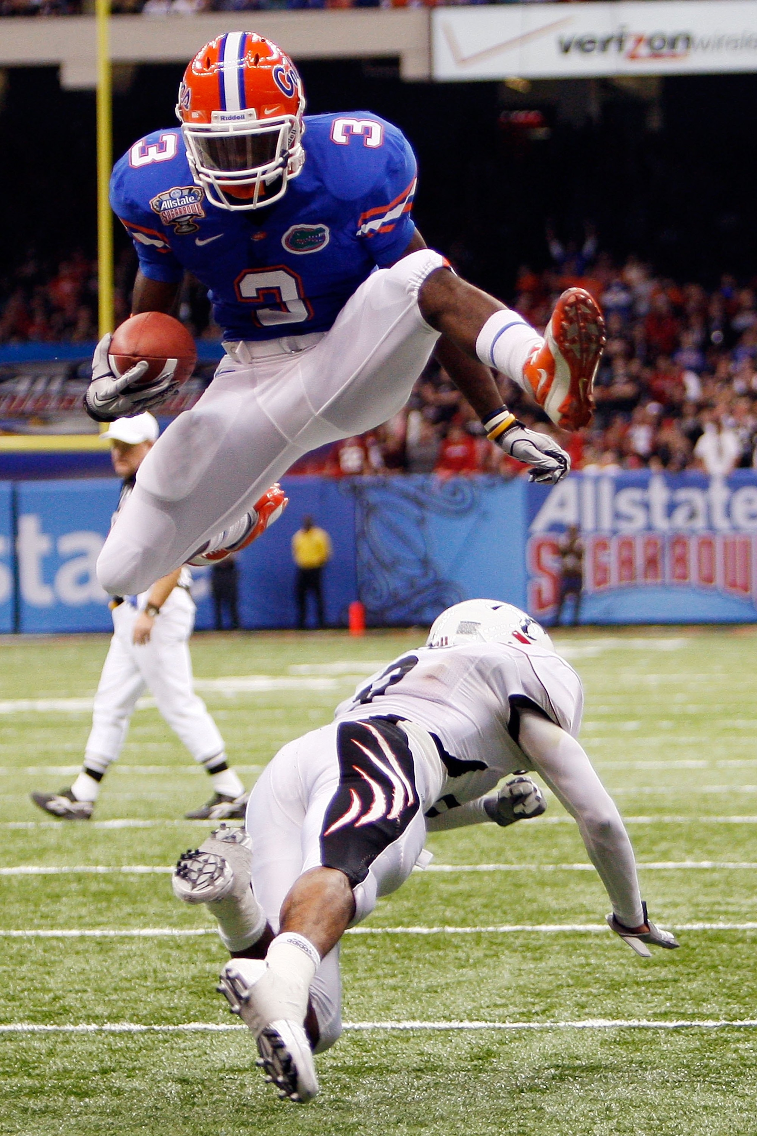 NEW ORLEANS - JANUARY 01:  Chris Rainey #3 of the Florida Gators jumps over Dominique Battle #9 of the Cincinnati Bearcats to score a touchdown during the Allstate Sugar Bowl at the Louisana Superdome on January 1, 2010 in New Orleans, Louisiana.  (Photo 