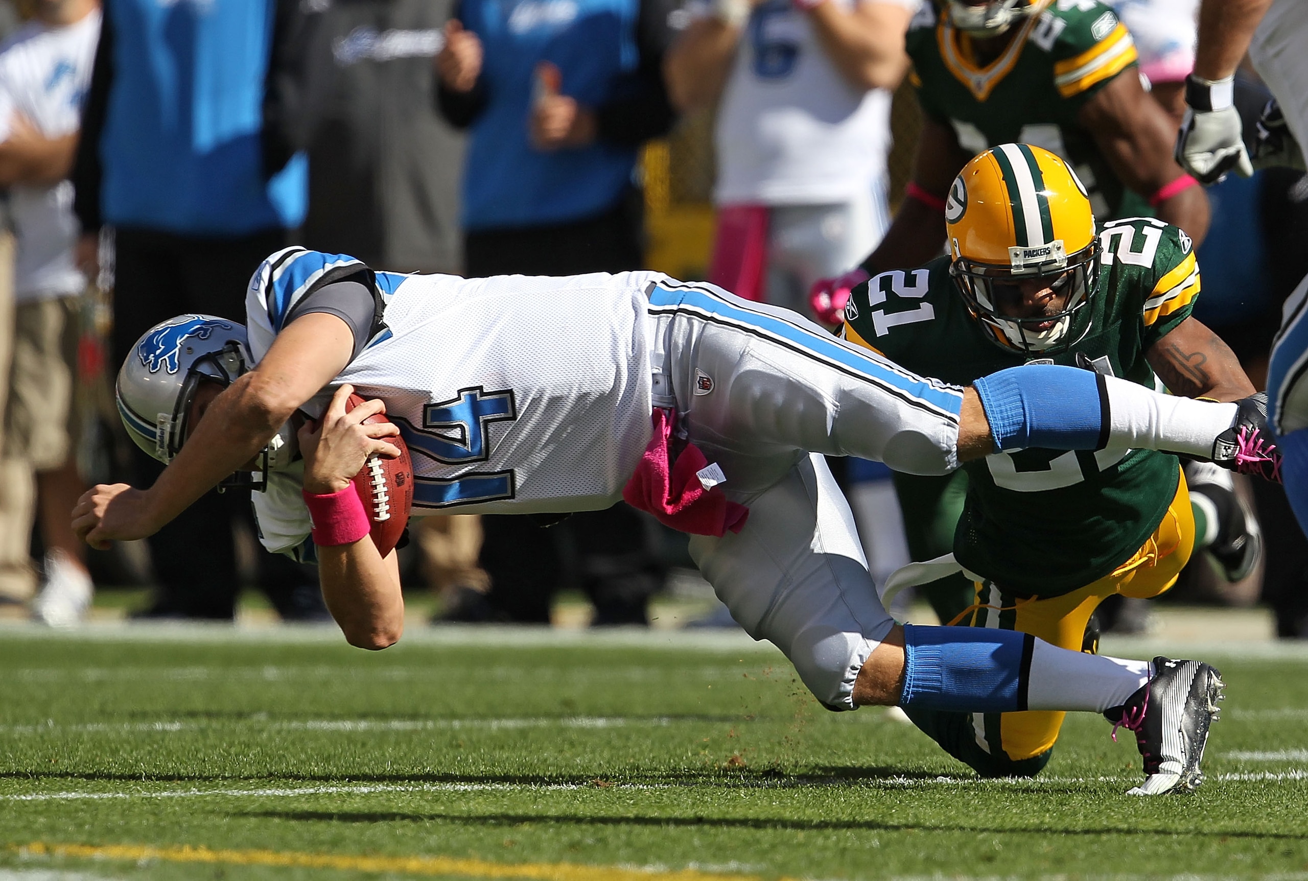 GREEN BAY, WI - OCTOBER 03: Charles Woodson #21 of the Green Bay Packers brings down Shaun Hill #14 of the Detroit Lions at Lambeau Field on October 3, 2010 in Green Bay, Wisconsin. The Packers defeated the Lions 28-26. (Photo by Jonathan Daniel/Getty Ima