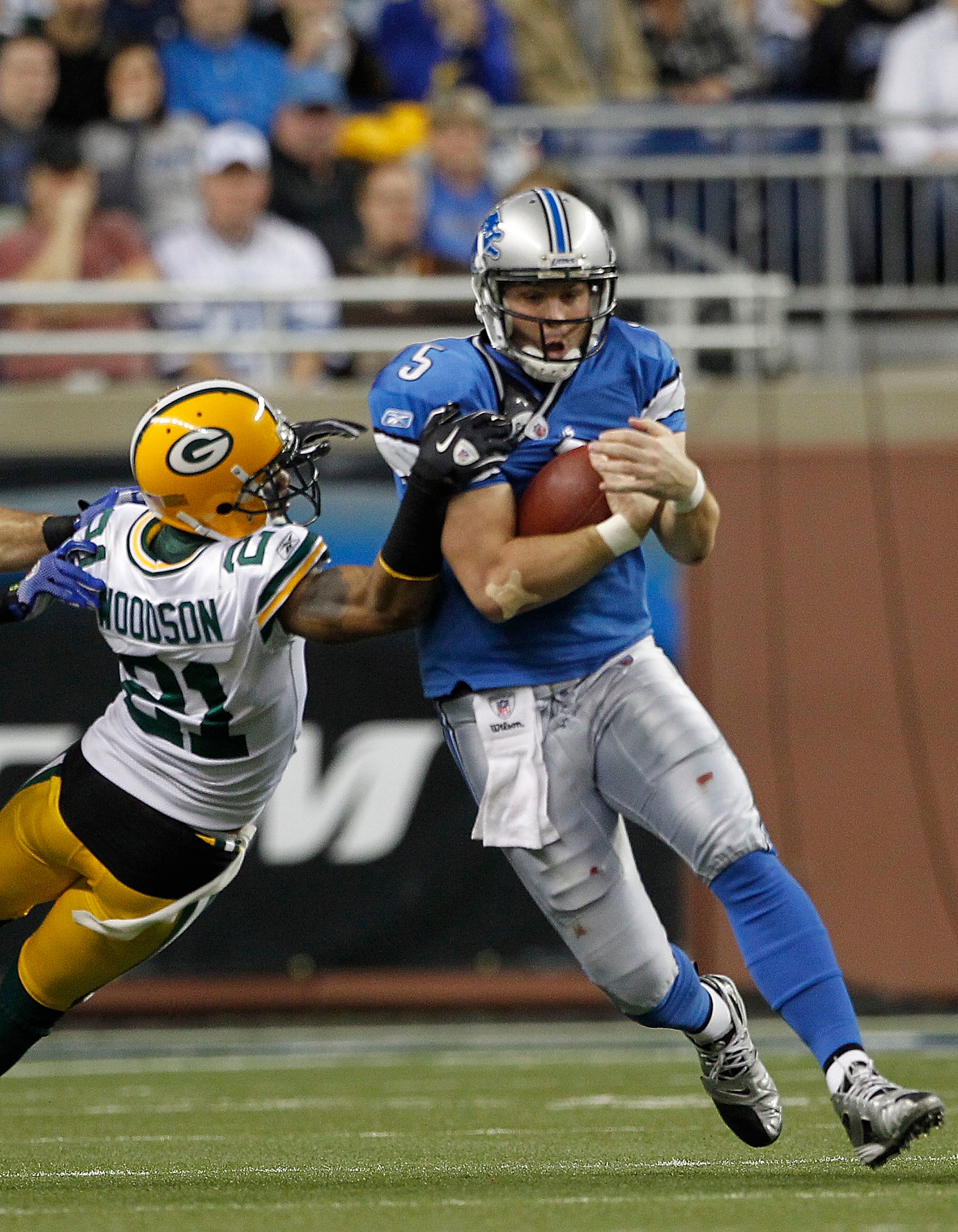 DETROIT - DECEMBER 12:  Drew Stanton #5 of the Detroit Lions runs for a first down as Charles Woodson #21 of the Green Bay Packers attempts to make the stop during the game at Ford Field on December 12, 2010 in Detroit, Michigan. The Lions defeated the Pa