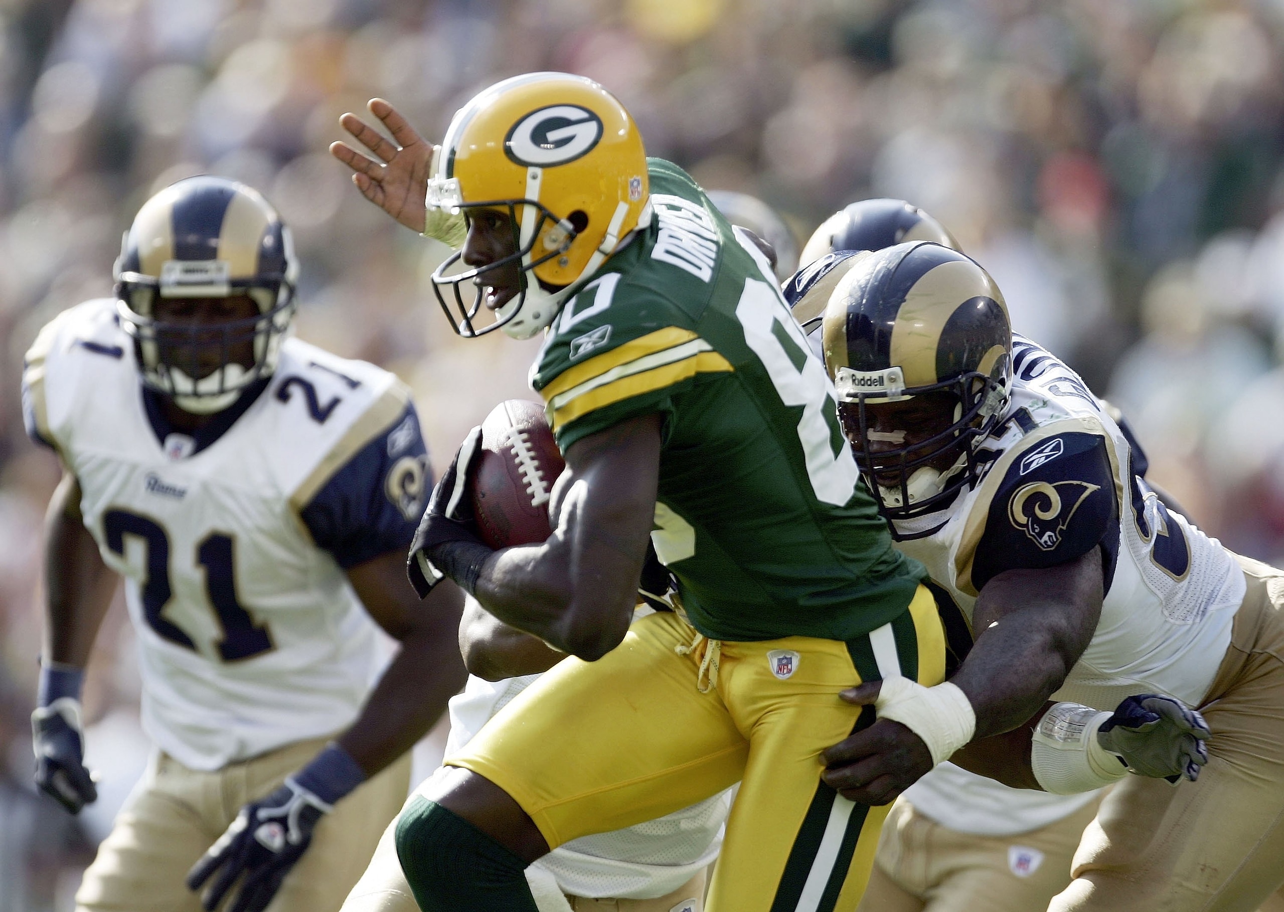 GREEN BAY, WI - OCTOBER 08:  Donald Driver #80 of the Green Bay Packers tries to break free from the tackle of La'Roi Glover #97 of the St. Louis Rams at Lambeau Field on October 8, 2006 in Green Bay, Wisconsin. The Rams won 23-20.  (Photo by Harry How/Ge
