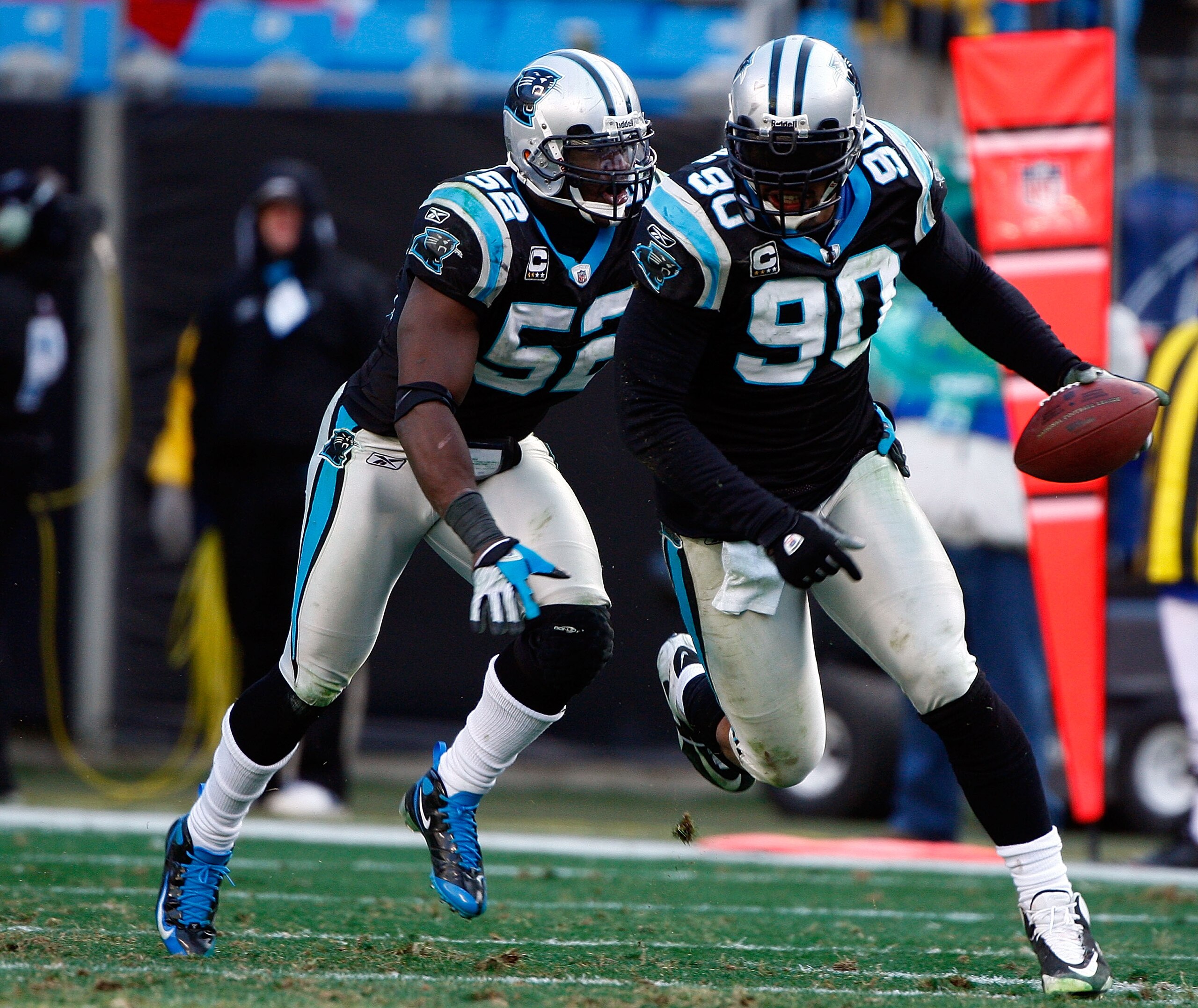 CHARLOTTE, NC - JANUARY 03: Julius Peppers #90 of the Carolina Panthers runs with the ball alongside teammate Jon Beason #52 after an interception against the New Orleans Saints in the second half of the game at Bank of America Stadium on January 3, 2010 CHARLOTTE, NC - JANUARY 03: Julius Peppers #90 of the Carolina Panthers runs with the ball alongside teammate Jon Beason #52 after an interception against the New Orleans Saints in the second half of the game at Bank of America Stadium on January 3, 2010