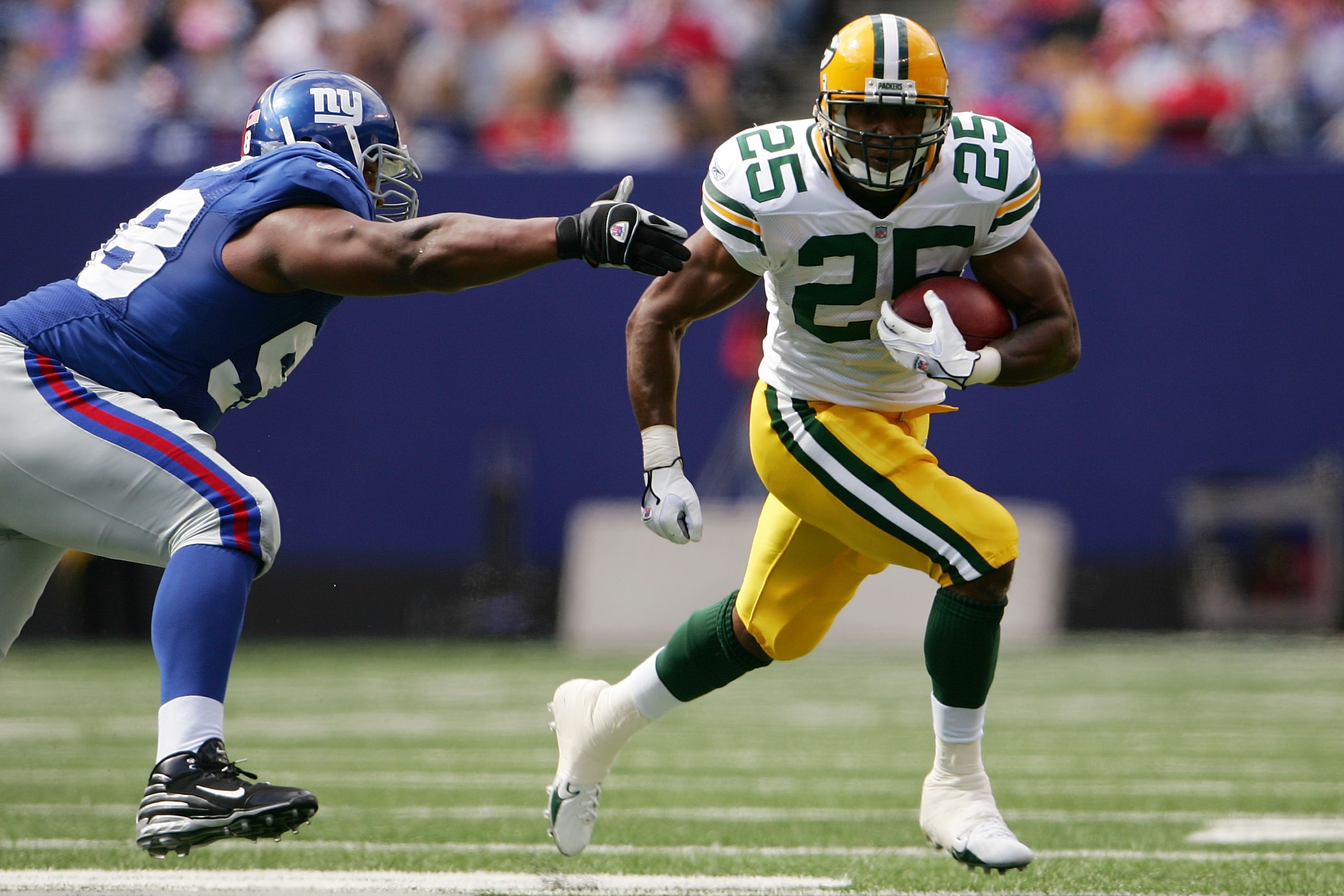 EAST RUTHERFORD, NJ - SEPTEMBER 16:  Ryan Grant #25 of the Green Bay Packers gets around Fred Robbins #98 of the New York Giants at Giants Stadium September 16, 2007 in East Rutherford, New Jersey.  (Photo by Chris McGrath/Getty Images)