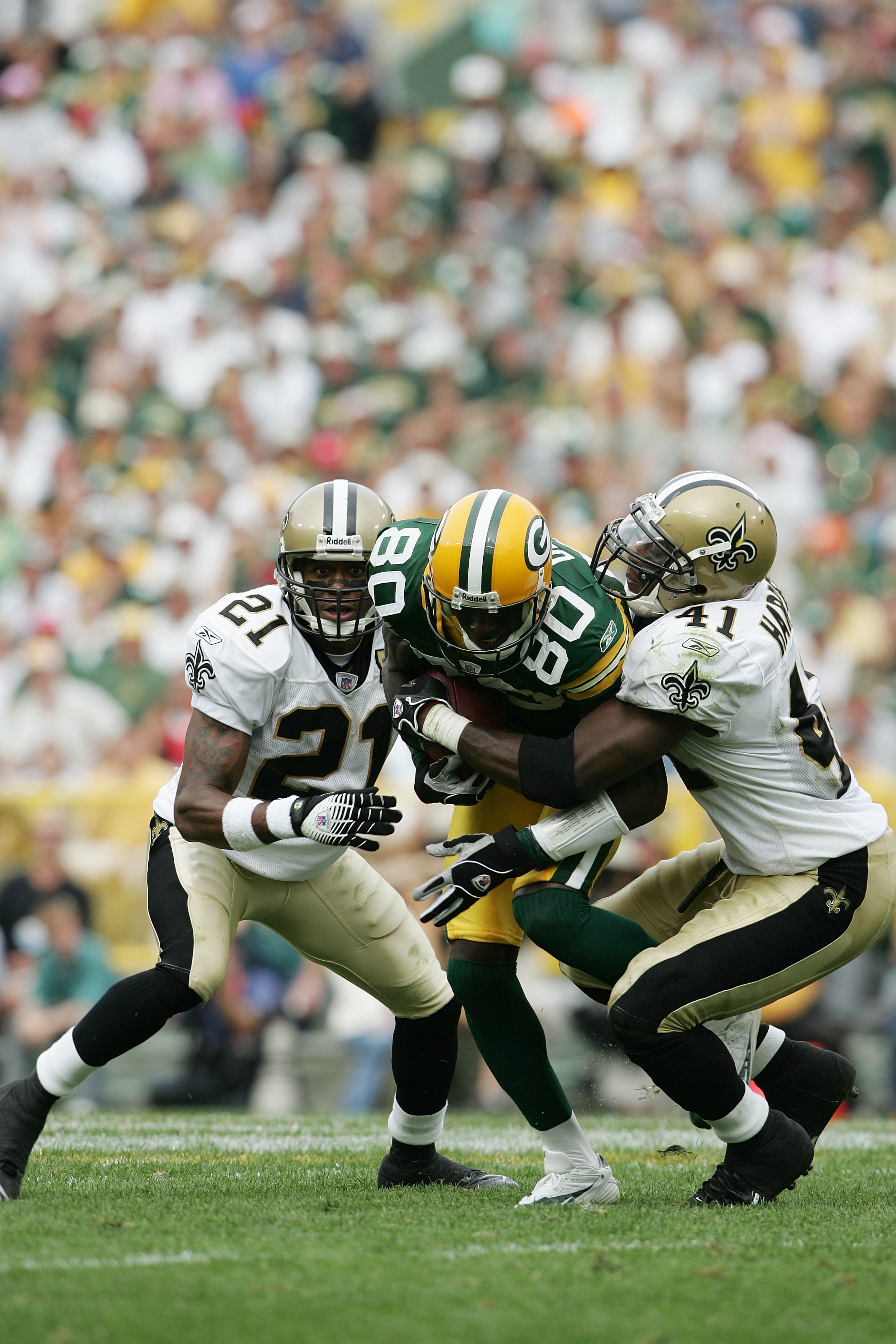 GREEN BAY, WI - SEPTEMBER 17:  Wide receiver Donald Driver #80 of the Green Bay Packers fights off the tackle attempt of cornerback Jason Craft #21 and safety Roman Harper #41 of the New Orleans Saints on September 17, 2006 at Lambeau Field in Green Bay,
