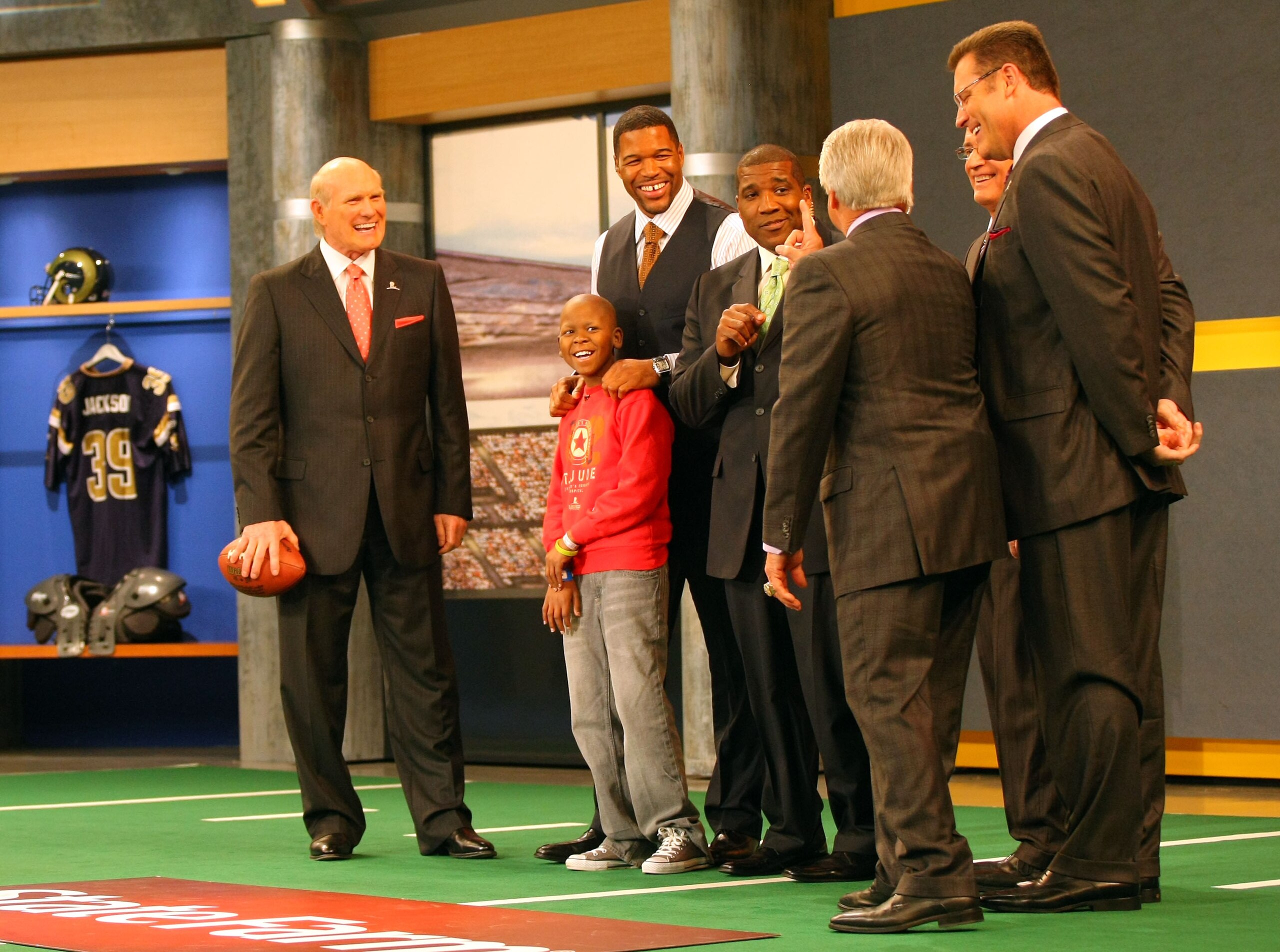 LOS ANGELES, CA - DECEMBER 12: (L-R) FOX NFL Sunday host Terry Bradshaw and analyst Michael Strahan, St. Jude Children's Research Hospital patient Markell and host Curt Menefee listen to analyst Jimmy Johnson (3rd from right)talk football strategy on set LOS ANGELES, CA - DECEMBER 12: (L-R) FOX NFL Sunday host Terry Bradshaw and analyst Michael Strahan, St. Jude Children's Research Hospital patient Markell and host Curt Menefee listen to analyst Jimmy Johnson (3rd from right)talk football strategy on set