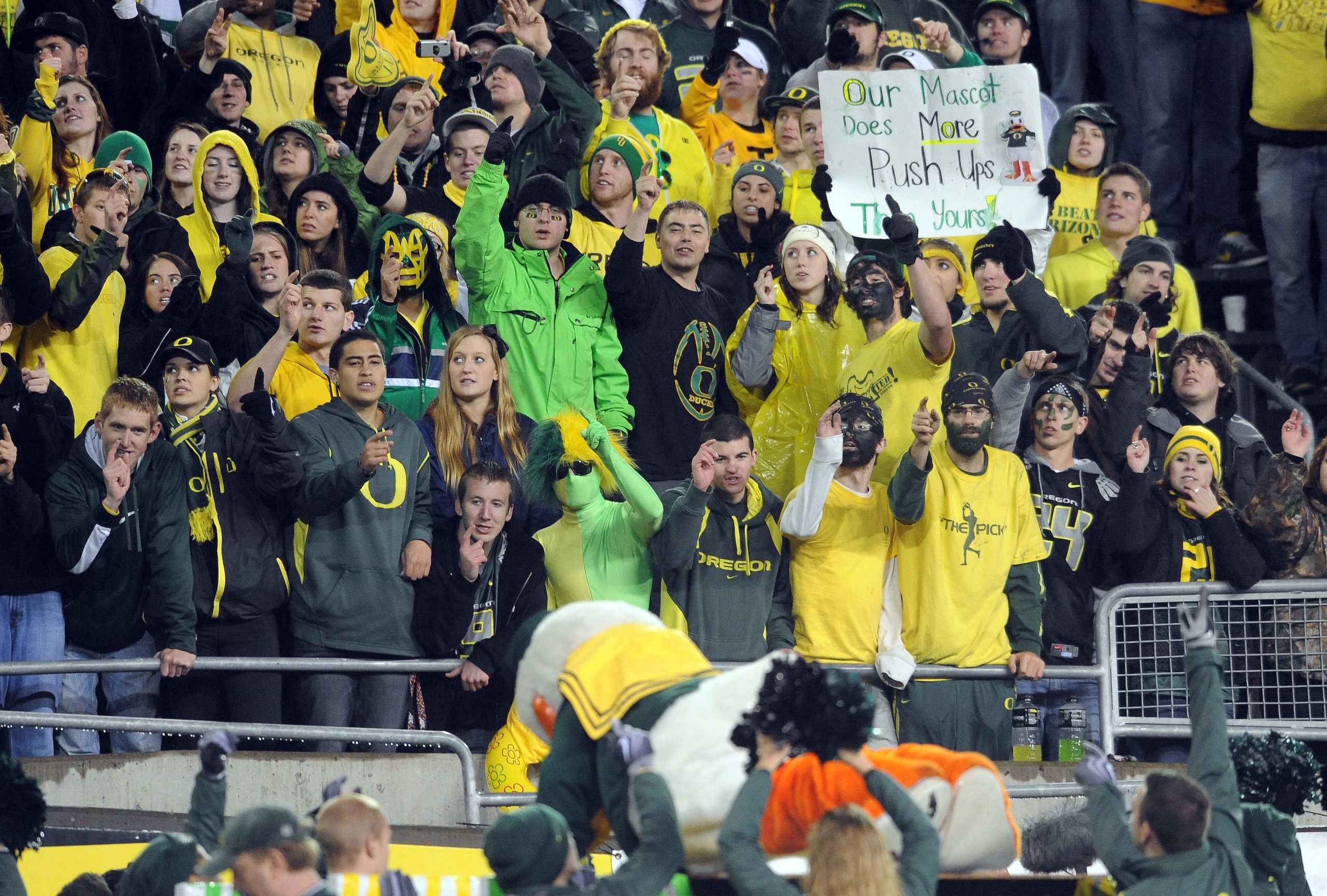 EUGENE, OR - NOVEMBER 26: Oregon Ducks fans cheer as mascot 'Puddles' does push ups in the fourth quarter of the game against the Arizona Wildcats at Autzen Stadium on November 26, 2010 in Eugene, Oregon. The Ducks won the game 48-29. (Photo by Steve Dyke