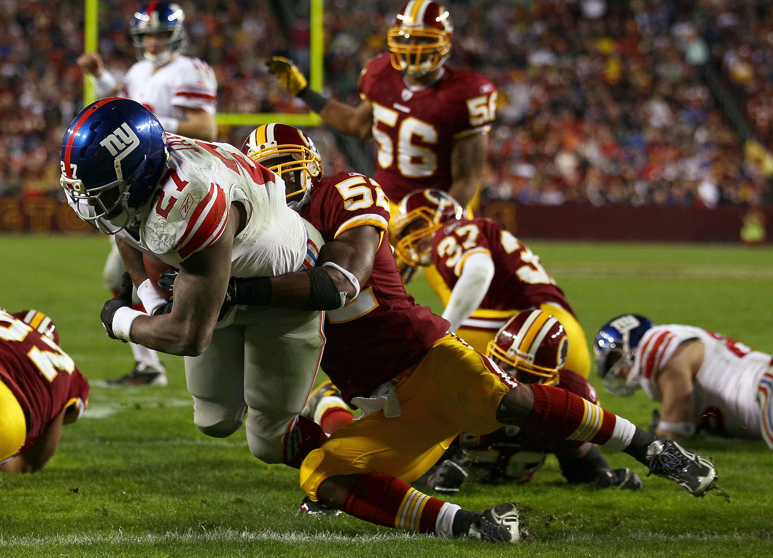 LANDOVER, MD - JANUARY 02: Brandon Jacobs #27 of the New York Giants drags Washington Redskins linebacker Rocky McIntosh into the end zone while scoring a touchdown during their game at FedEx Field on January 2, 2011 in Landover, Maryland.  (Photo by Win 