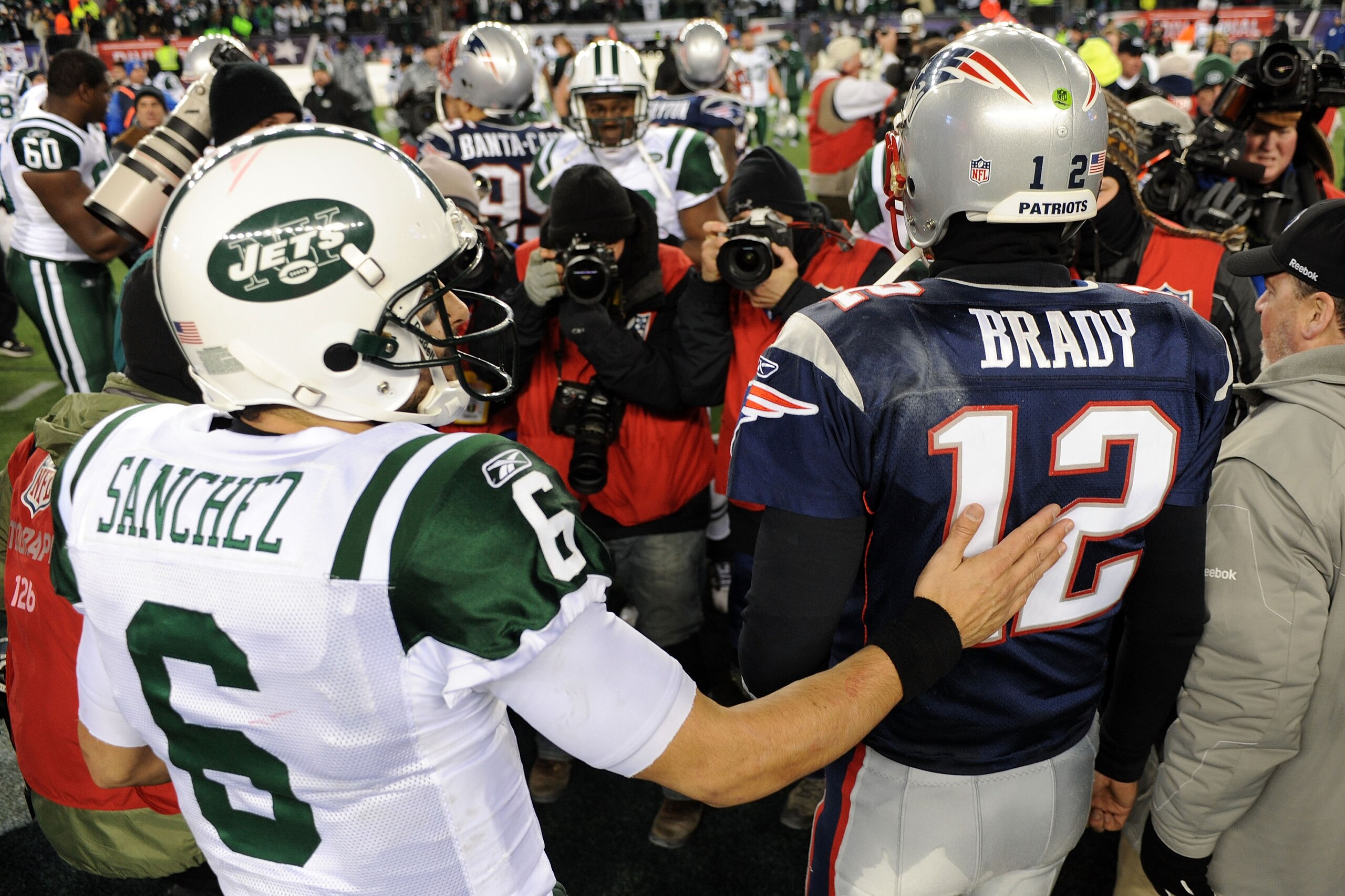 FOXBORO, MA - JANUARY 16:  Tom Brady #12 of the New England Patriots and Mark Sanchez #6 of the New York Jets walk off the field after the Jets defeated the Patriots 28 to 21 their 2011 AFC divisional playoff game at Gillette Stadium on January 16, 2011 i