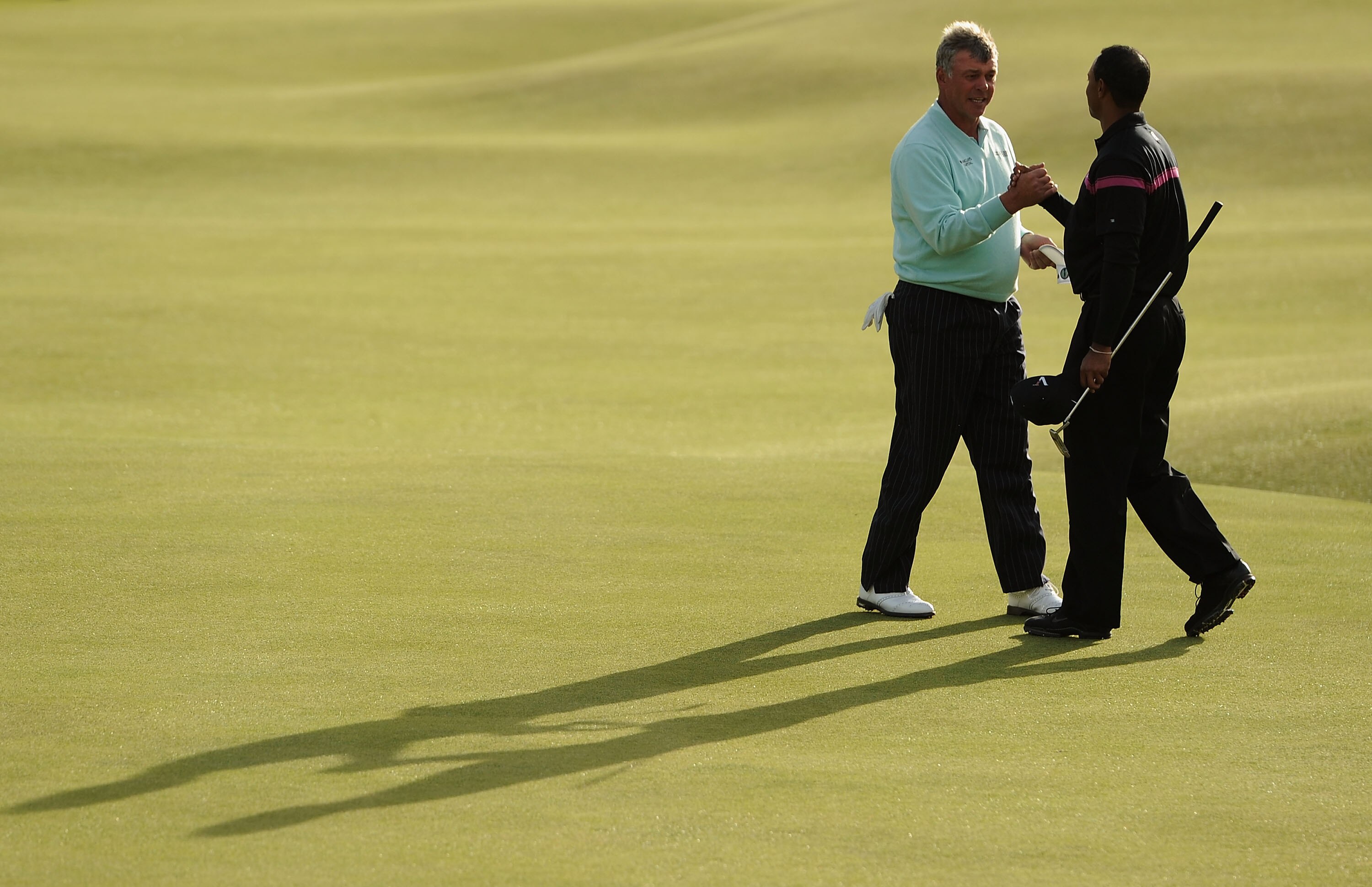 ST ANDREWS, SCOTLAND - JULY 17:  (L-R) Darren Clarke of Northern Ireland shakes hands with Tiger Woods of the USA on the 18th green during the third round of the 139th Open Championship on the Old Course, St Andrews on July 17, 2010 in St Andrews, Scotlan