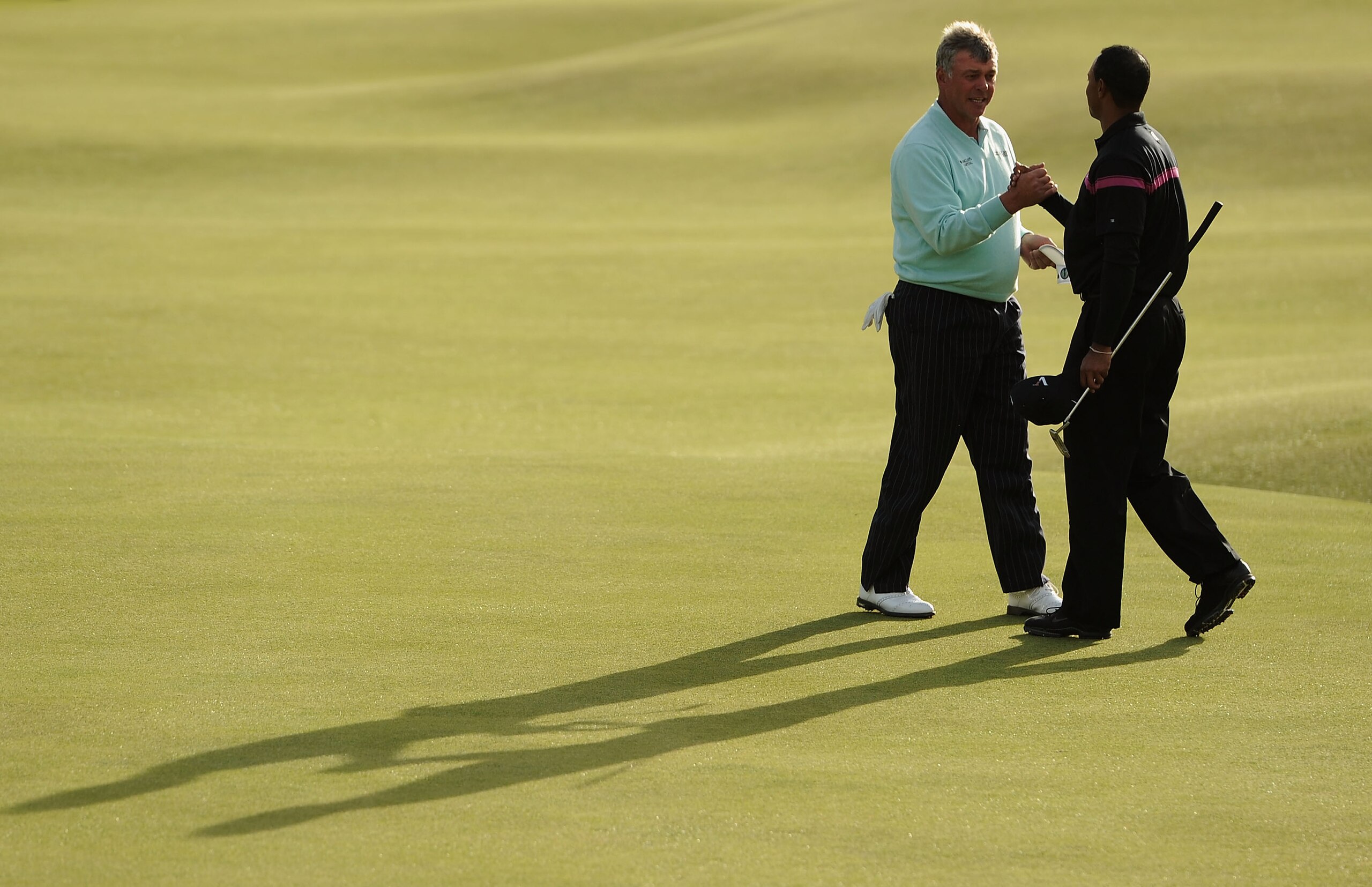 ST ANDREWS, SCOTLAND - JULY 17:  (L-R) Darren Clarke of Northern Ireland shakes hands with Tiger Woods of the USA on the 18th green during the third round of the 139th Open Championship on the Old Course, St Andrews on July 17, 2010 in St Andrews, Scotlan