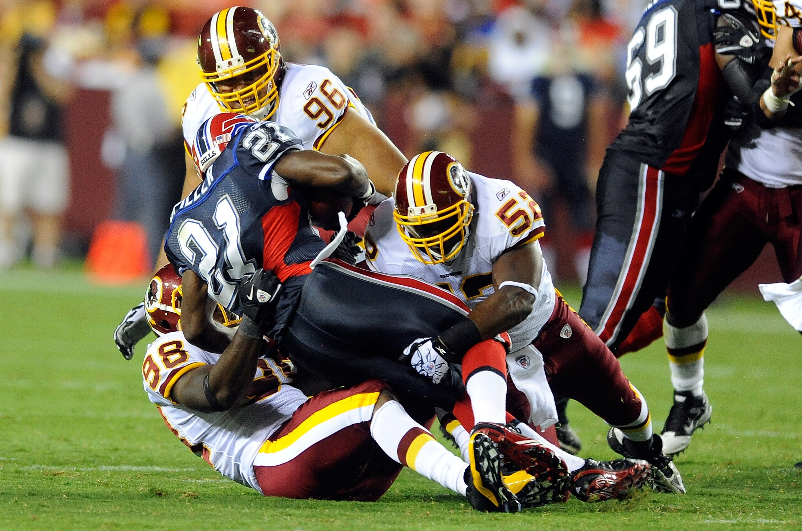 LANDOVER, MD - AUGUST 13:  Brian Orakpo #98, Rocky McIntosh #52 and Ma'ake Kemoeatu #96 of the Washington Redskins tackle C.J. Spiller #21 of the Buffalo Bills during the preseason game at FedEx Field on August 13, 2010 in Landover, Maryland.  (Photo by G