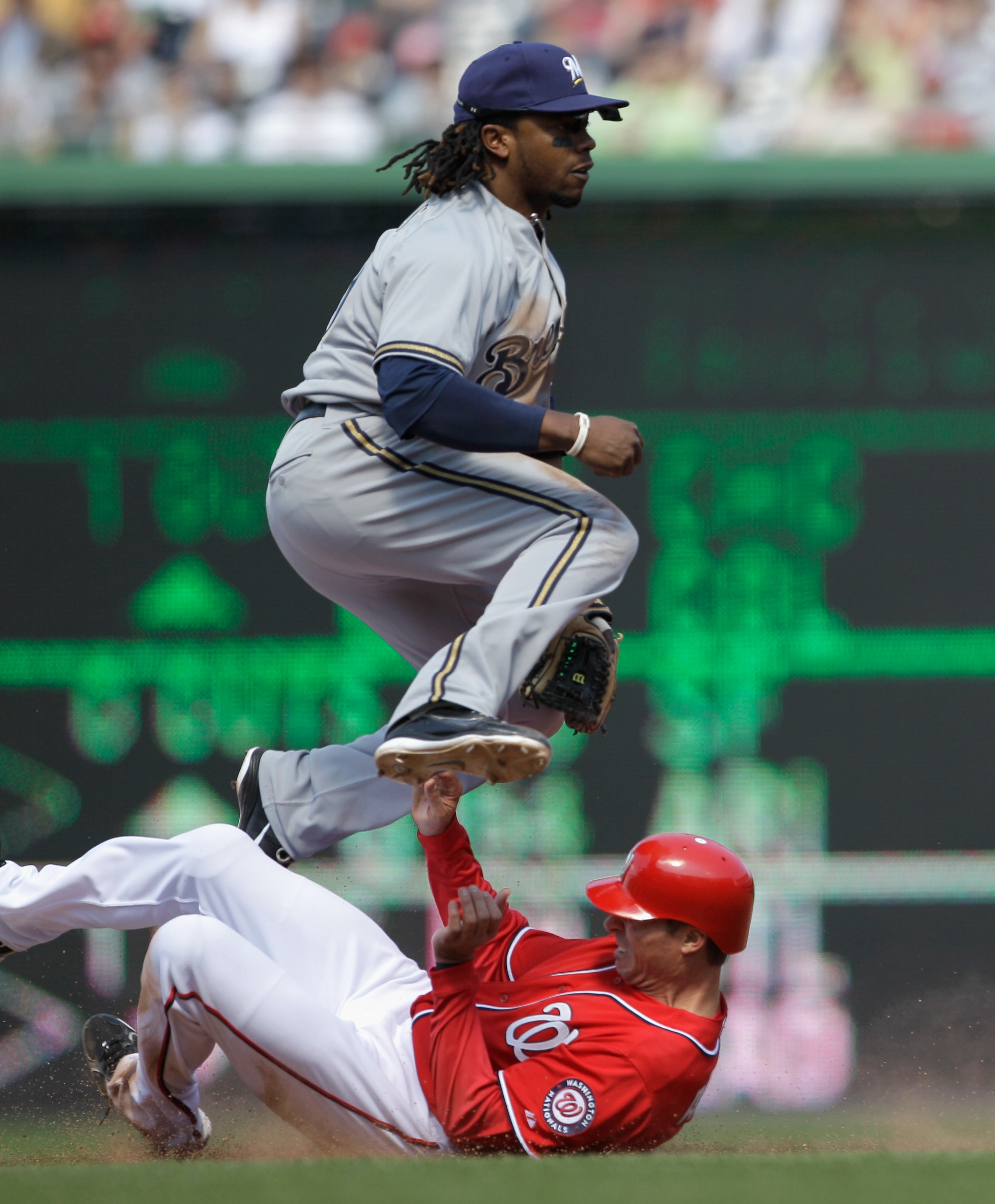 WASHINGTON, DC - APRIL 17:  Rickie Weeks #23 of the Milwaukee Brewers jumps over baserunner Rick Ankiel #43 of the Washington Nationals after being forced out at second base on a double play during the fifth inning of game one of a doubleheader at Nationa
