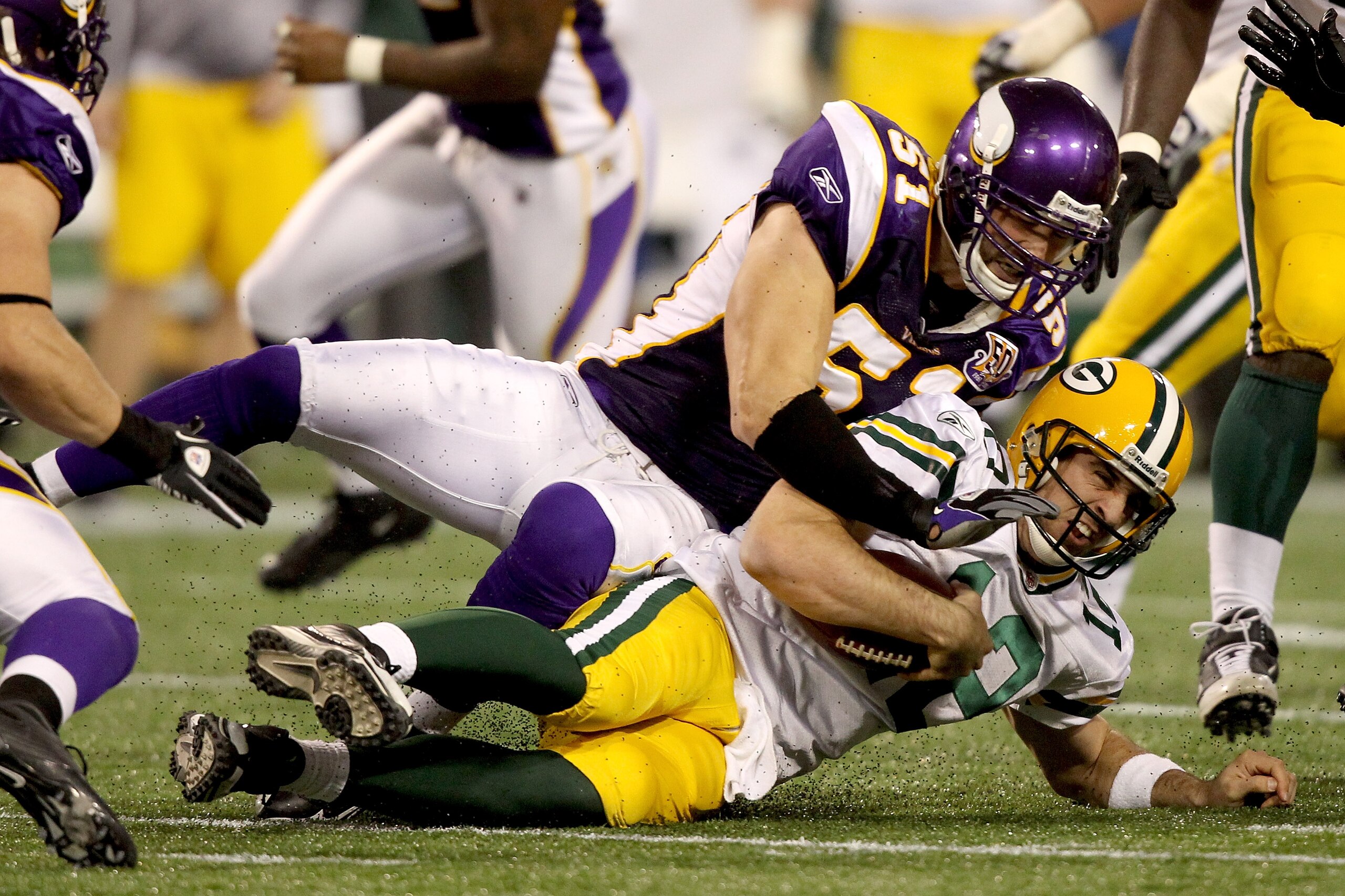 MINNEAPOLIS - NOVEMBER 21:  Quarterback Aaron Rodgers #12 of the Green Bay Packers is hit by Ben Leber #51 of the Minnesota Vikings after being chased from the pocket at the Hubert H. Humphrey Metrodome on November 21, 2010 in Minneapolis, Minnesota.  (Ph