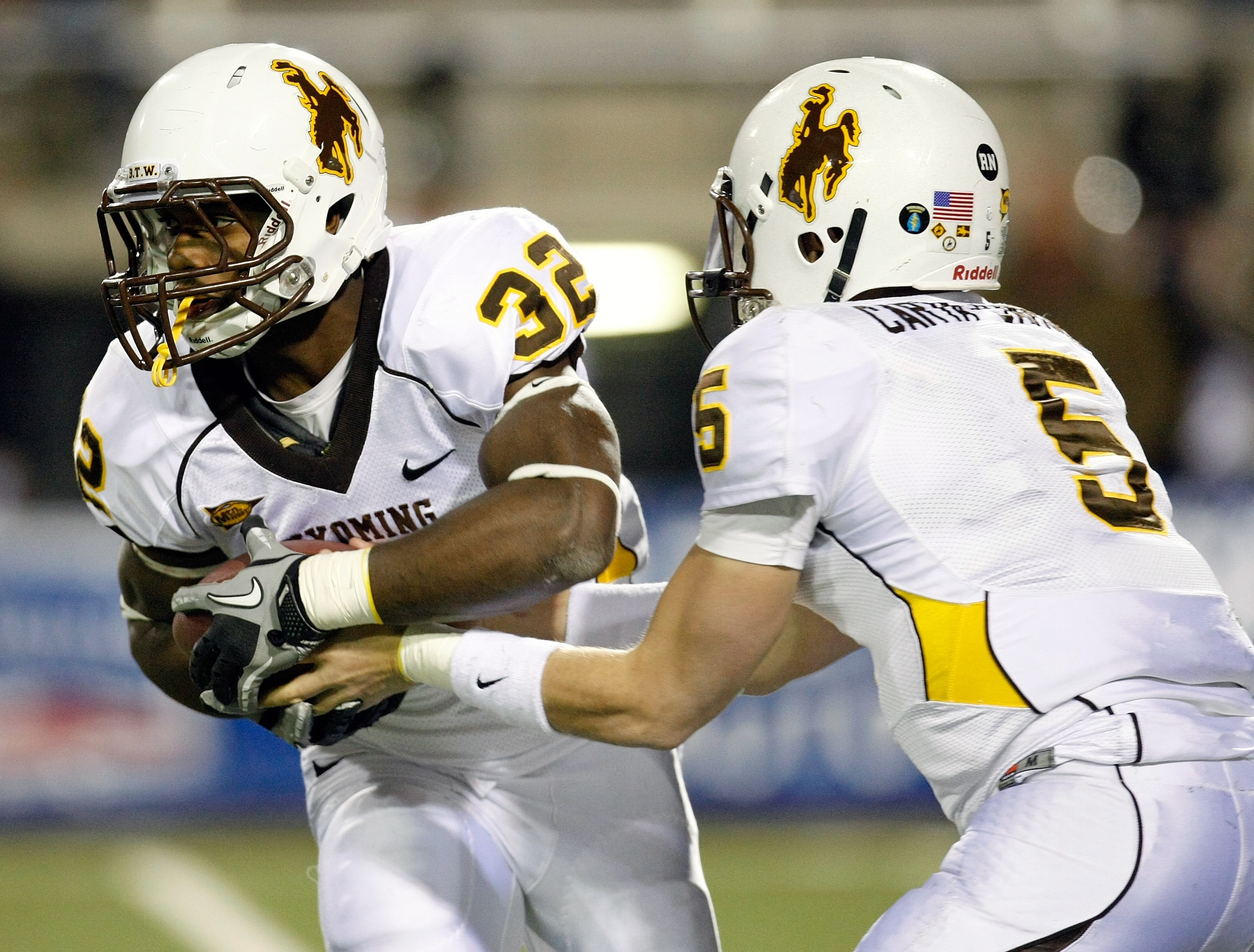 LAS VEGAS - NOVEMBER 13: Alvester Alexander #32 of the Wyoming Cowboys takes a handoff from quarterback Austyn Carta-Samuels #5 during their game against the UNLV Rebels at Sam Boyd Stadium November 13, 2010 in Las Vegas, Nevada. UNLV won 42-16. (Photo LAS VEGAS - NOVEMBER 13: Alvester Alexander #32 of the Wyoming Cowboys takes a handoff from quarterback Austyn Carta-Samuels #5 during their game against the UNLV Rebels at Sam Boyd Stadium November 13, 2010 in Las Vegas, Nevada. UNLV won 42-16. (Photo