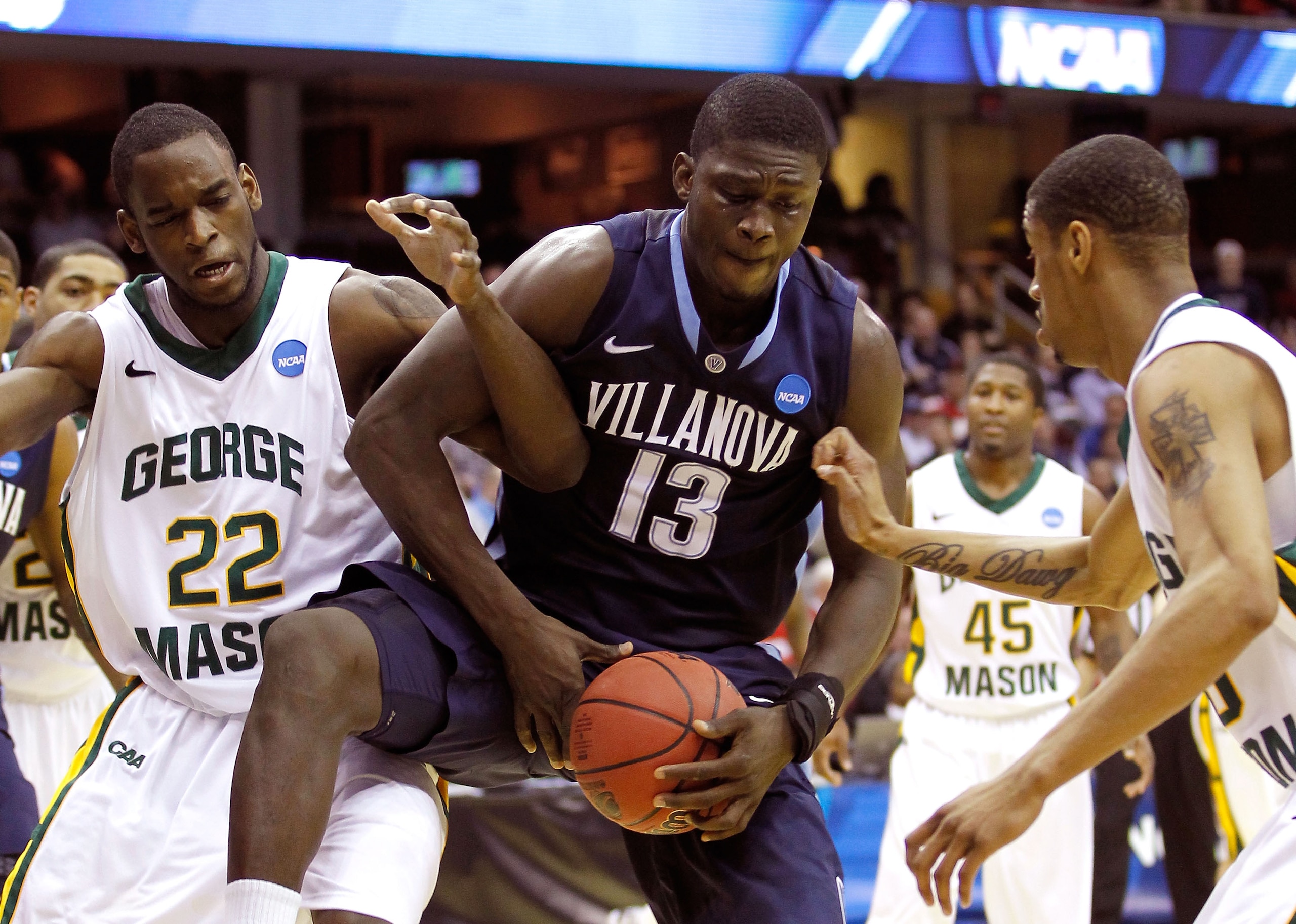 CLEVELAND, OH - MARCH 18: Mouphtaou Yarou #13 of the Villanova Wildcats fights for a loose ball with Mike Morrison #22 of the George Mason Patriots during the second round of the 2011 NCAA men's basketball tournament at Quicken Loans Arena on March 18, 20