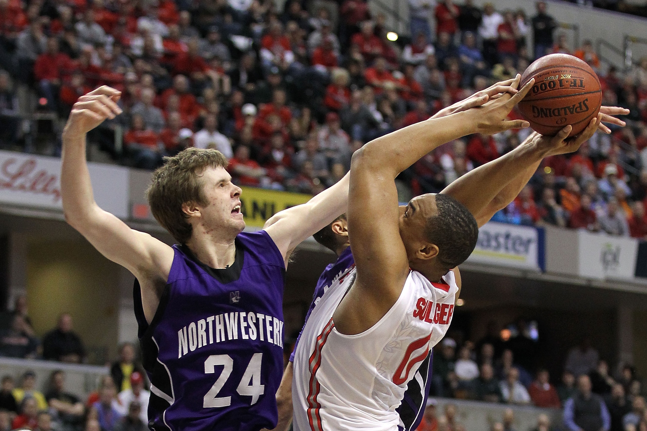 INDIANAPOLIS, IN - MARCH 11:  Jared Sullinger #0 of the Ohio State Buckeyes is fouled on a shot attempt by John Shurna #24 of the Northwestern Wildcats during the quarterfinals of the 2011 Big Ten Men's Basketball Tournament at Conseco Fieldhouse on March