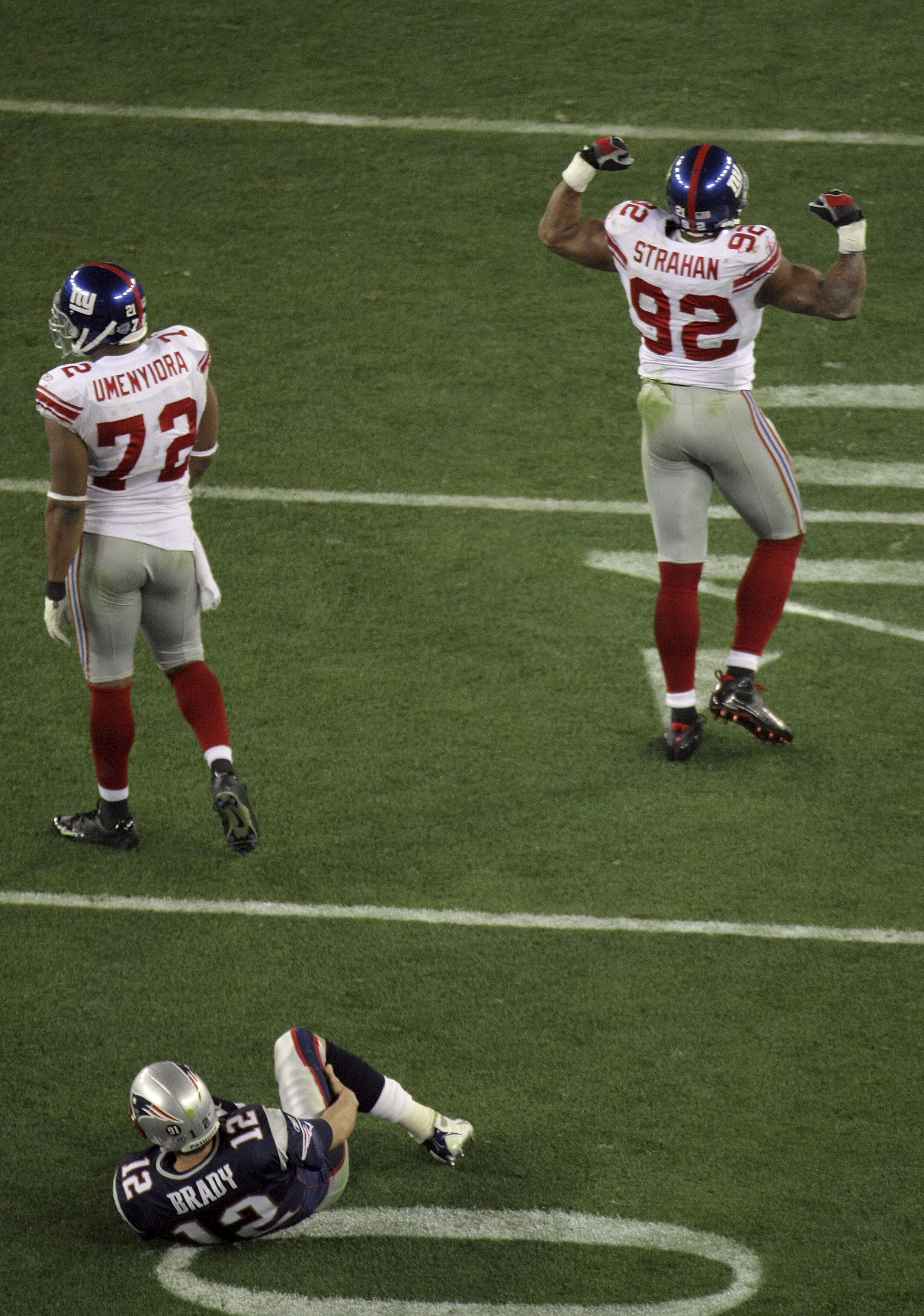 GLENDALE, AZ - FEBRUARY 03:  Quarterback Tom Brady #12 of the New England Patriots lies on his back after being sacked by defensive end Michael Strahan #92 of the New York Giants in the third quarter during Super Bowl XLII on February 3, 2008 at the Unive