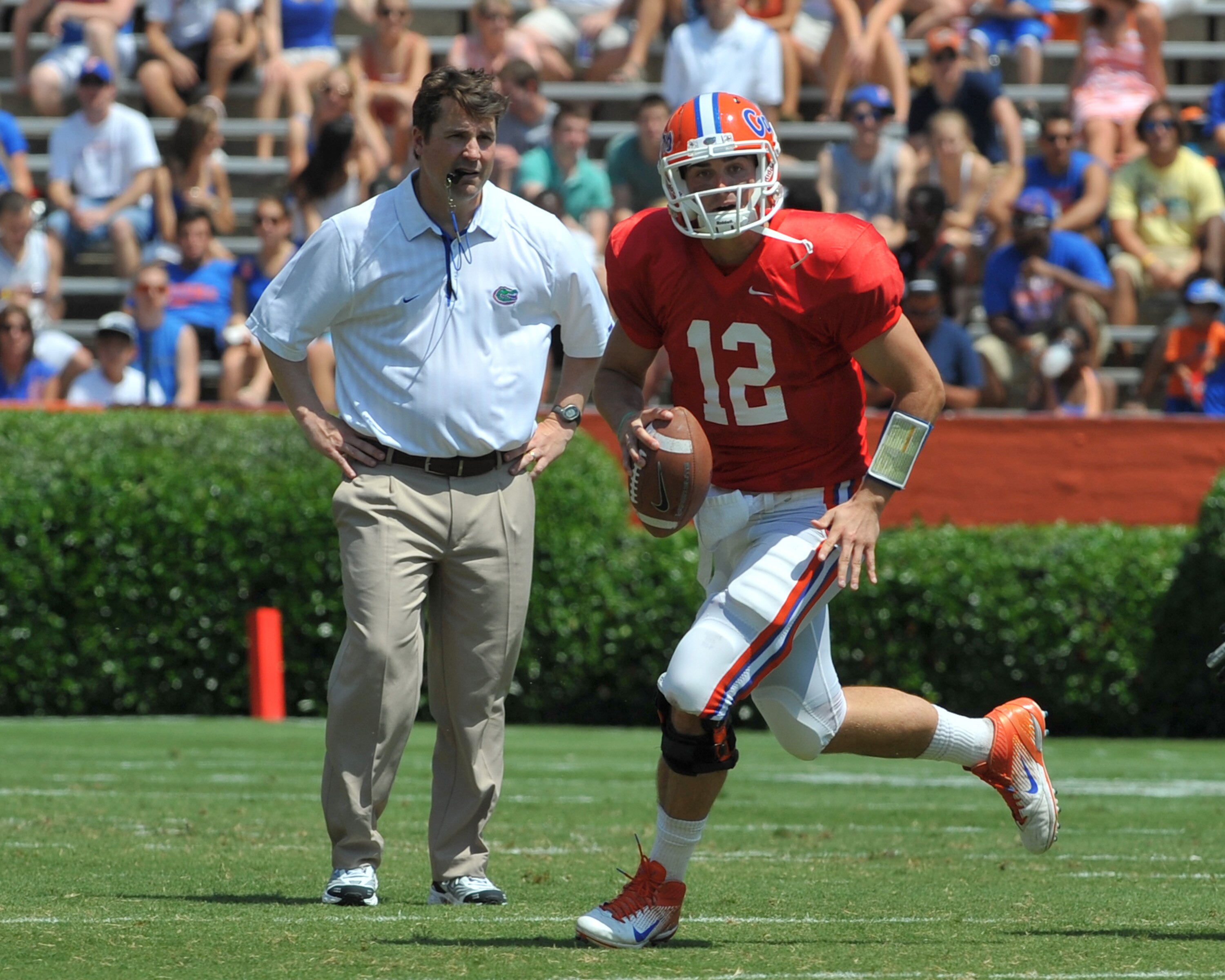 GAINESVILLE, FL - APRIL 9:  Quarterback John Brantley #12 of the Florida Gators runs from the pocket in front of coach Will Muschamp during the Orange and Blue spring football game April 9, 2011 at Ben Hill Griffin Stadium in Gainesville, Florida.  (Photo