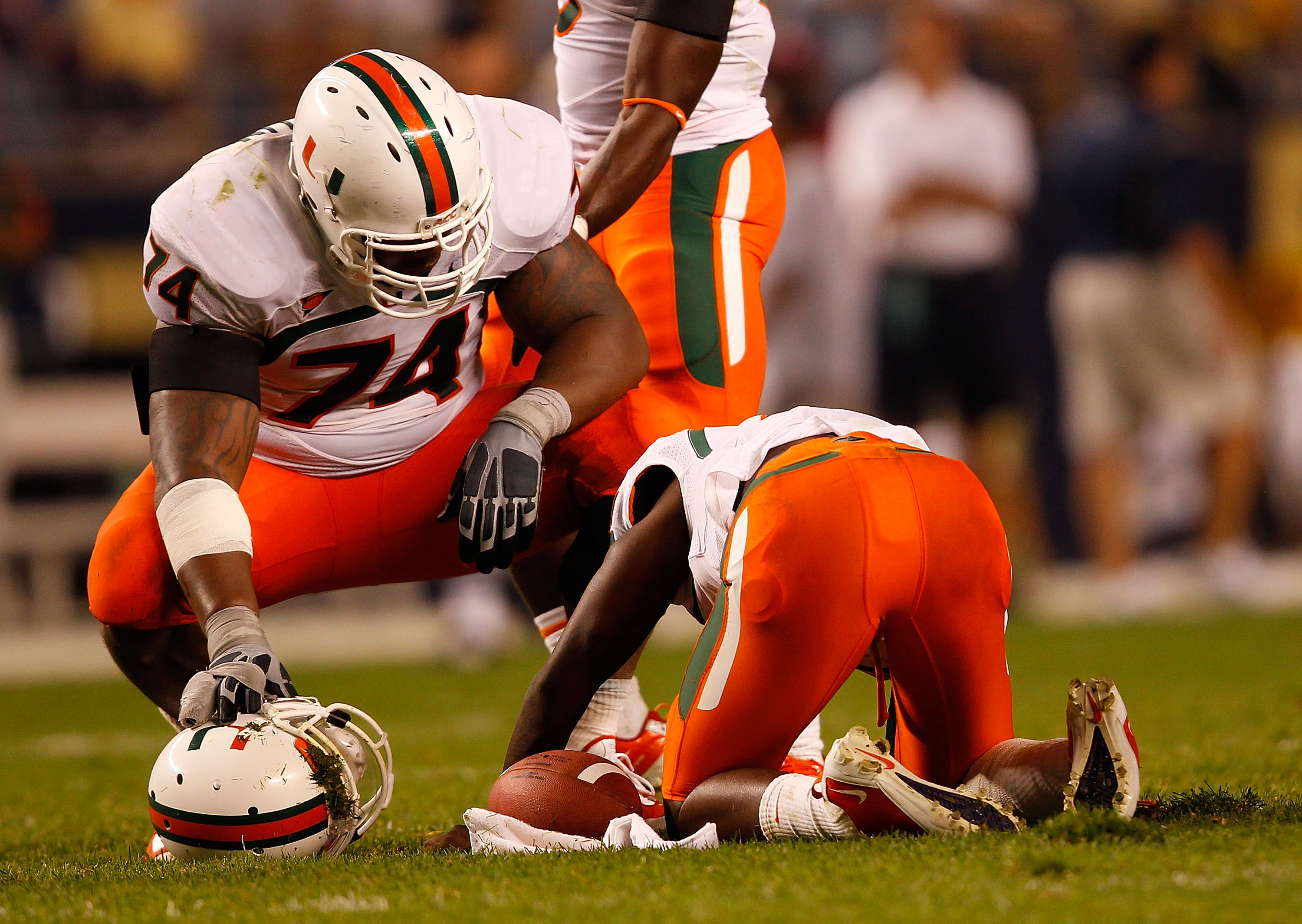 PITTSBURGH - SEPTEMBER 23:  Jacory Harris #12 of the Miami Hurricanes lays on the ground as teammate Orlando Franklin #74 looks on after being sacked by the Pittsburgh Panthers on September 23, 2010 at Heinz Field in Pittsburgh, Pennsylvania.  (Photo by J