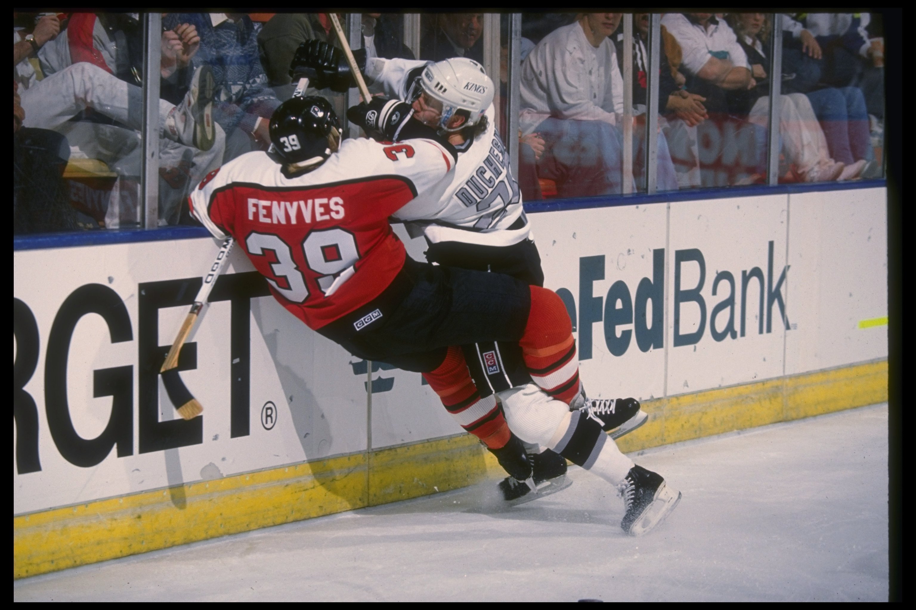 27 Dec 1990: Defenseman Steve Duchesne of the Los Angeles Kings and defenseman Dave Fenyves of the Philadelphia Flyers meet at the wall during a game at the Great Western Forum in Inglewood, California. The Flyers won the game, 7-5.