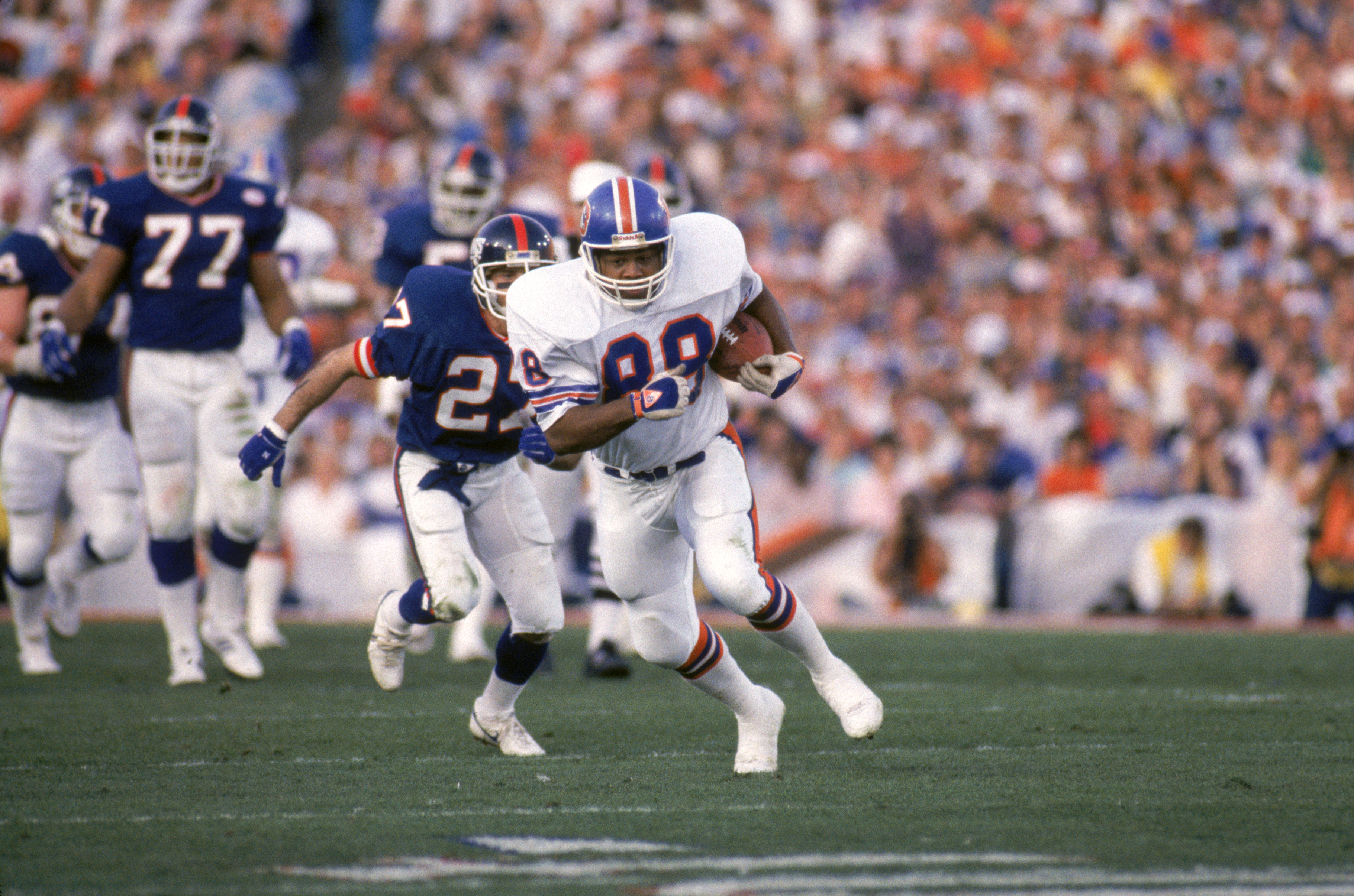 PASADENA, CA - JANUARY 25:  Tight end Clarence Kay #88 of the Denver Broncos hustles for yards past defensive back Herb Welch #27 of the New York Giants during Super Bowl XXI at the Rose Bowl on January 25, 1987 in Pasadena, California.  The Giants won 39