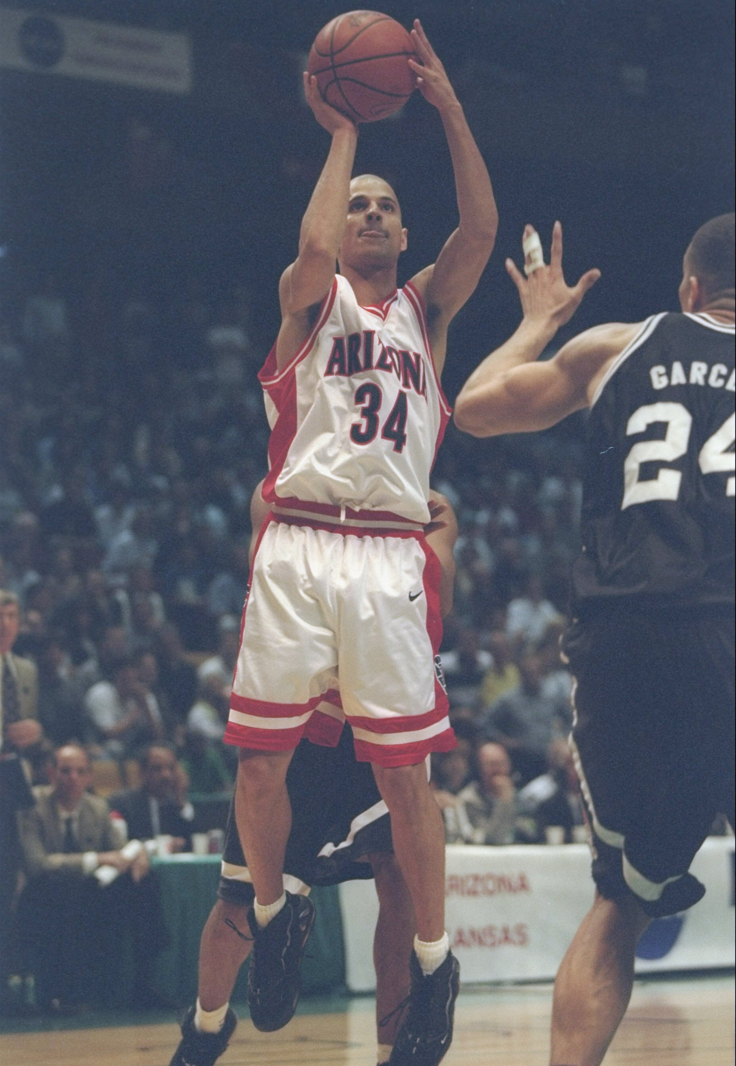 23 Mar 1997:  Guard Miles Simon of the Arizona Wildcats shoots the ball over center Ruben Garces of the Providence Friars during a playoff game at the Birmingham-Jefferson Civic Center in Birmingham, Alabama.  Arizona won the game 96 - 92. Mandatory Credi