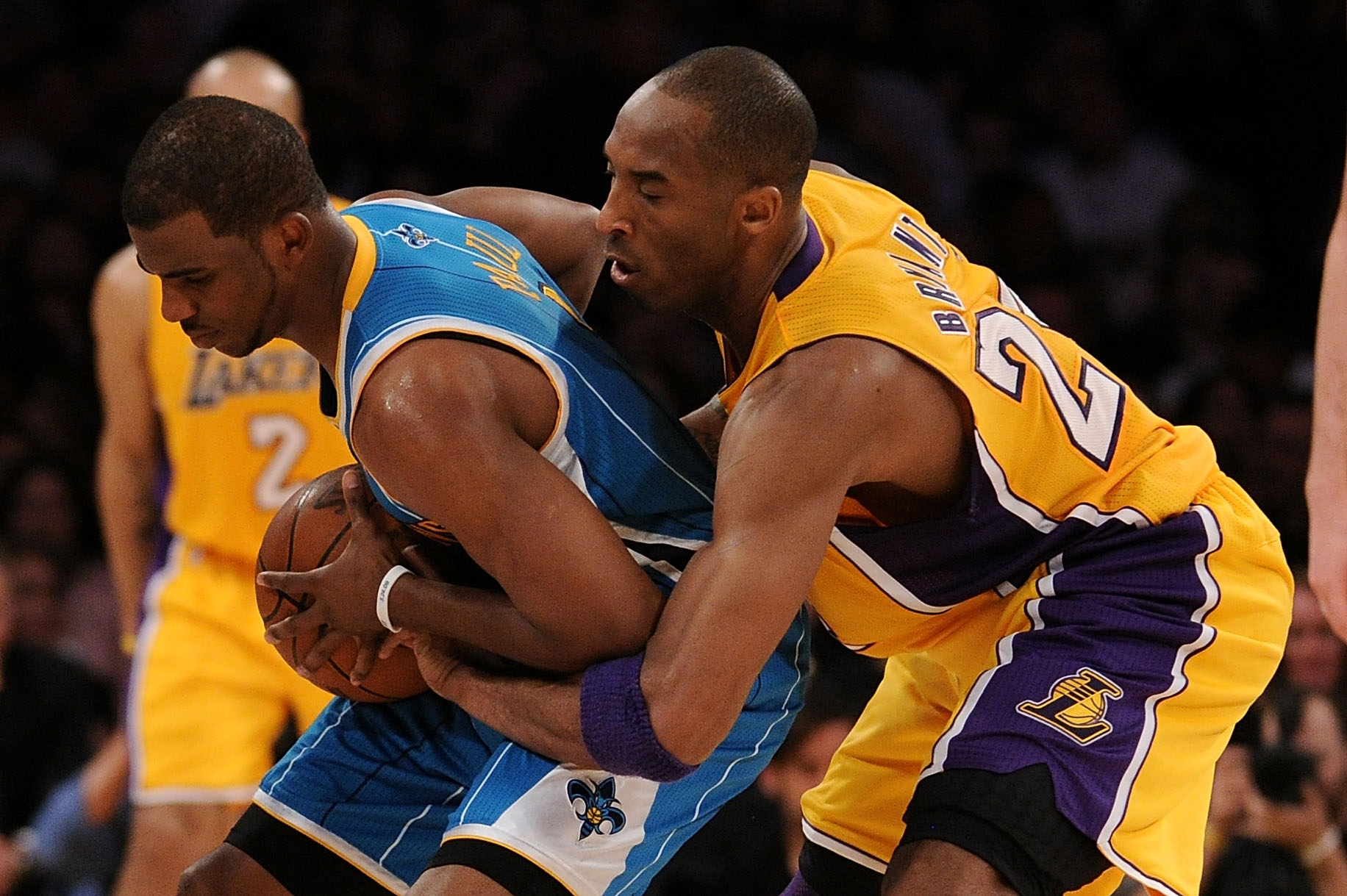 LOS ANGELES, CA - APRIL 20:  Chris Paul #3 of the New Orleans Hornets holds the ball as Kobe Bryant #24 of the Los Angeles Lakers goes after it from behind in the second quarter in Game Two of the Western Conference Quarterfinals in the 2011 NBA Playoffs