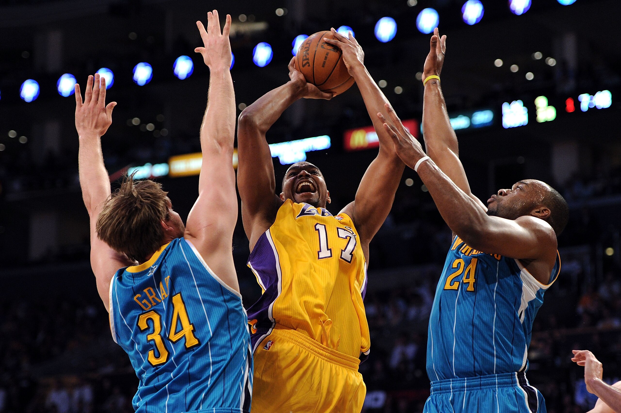 LOS ANGELES, CA - APRIL 20:  Andrew Bynum #17 of the Los Angeles Lakers shoots over Aaron Gray #34 and Carl Landry #24 of the New Orleans Hornets in the first quarter in Game Two of the Western Conference Quarterfinals in the 2011 NBA Playoffs on April 20