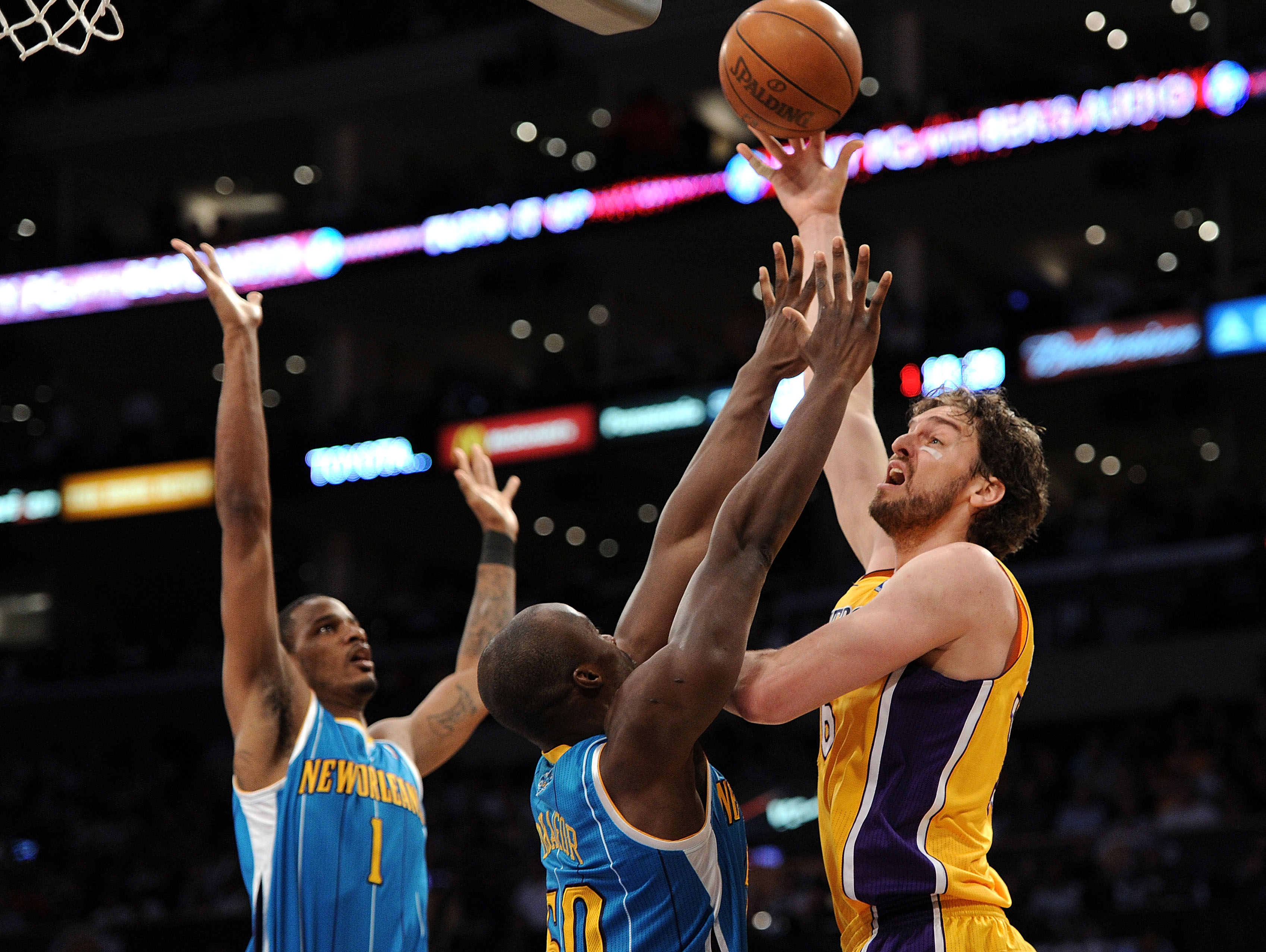 LOS ANGELES, CA - APRIL 20:  Pau Gasol #16 of the Los Angeles Lakers shoots over Emeka Okafor #50 and Trevor Ariza #1 of the New Orleans Hornets in the first quarter in Game Two of the Western Conference Quarterfinals in the 2011 NBA Playoffs on April 20,
