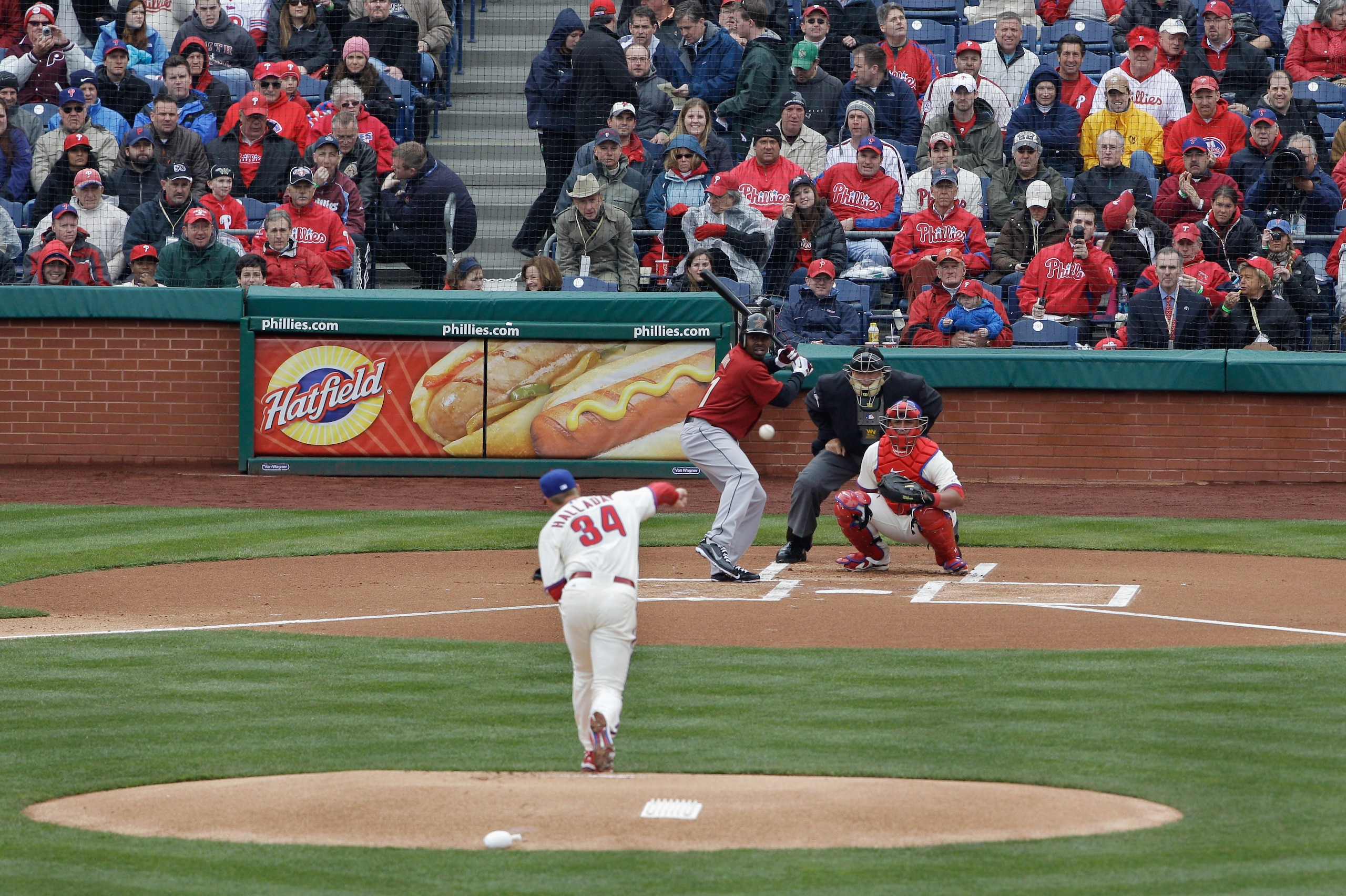 PHILADELPHIA, PA - APRIL 01:  Starting pitcher Roy Halladay #34 of the Philadelphia Phillies delivers the first pitch of opening day to batter Michael Bourn #21 of the Houston Astros as catcher Carlos Ruiz #51 of the Philadelphia Phillies and home plate u