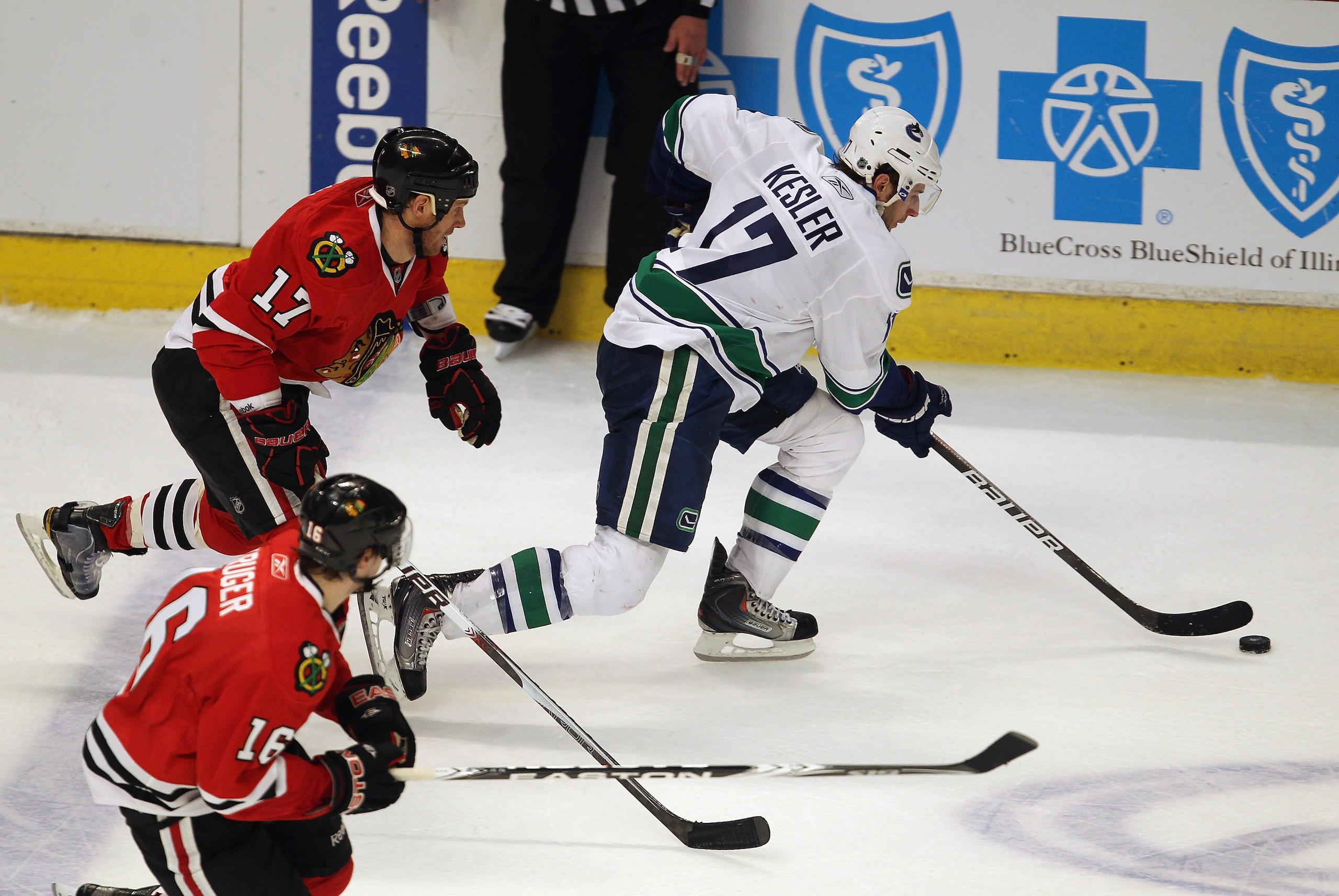 CHICAGO, IL - APRIL 19: Ryan Kesler #17 of the Vancouver Canucksis chased by Ryan Johnson #17 and Marcus Kruger #16 of the Chicago Blackhawks in Game Four of the Western Conference Quarterfinals during the 2011 NHL Stanley Cup Playoffs at the United Cente
