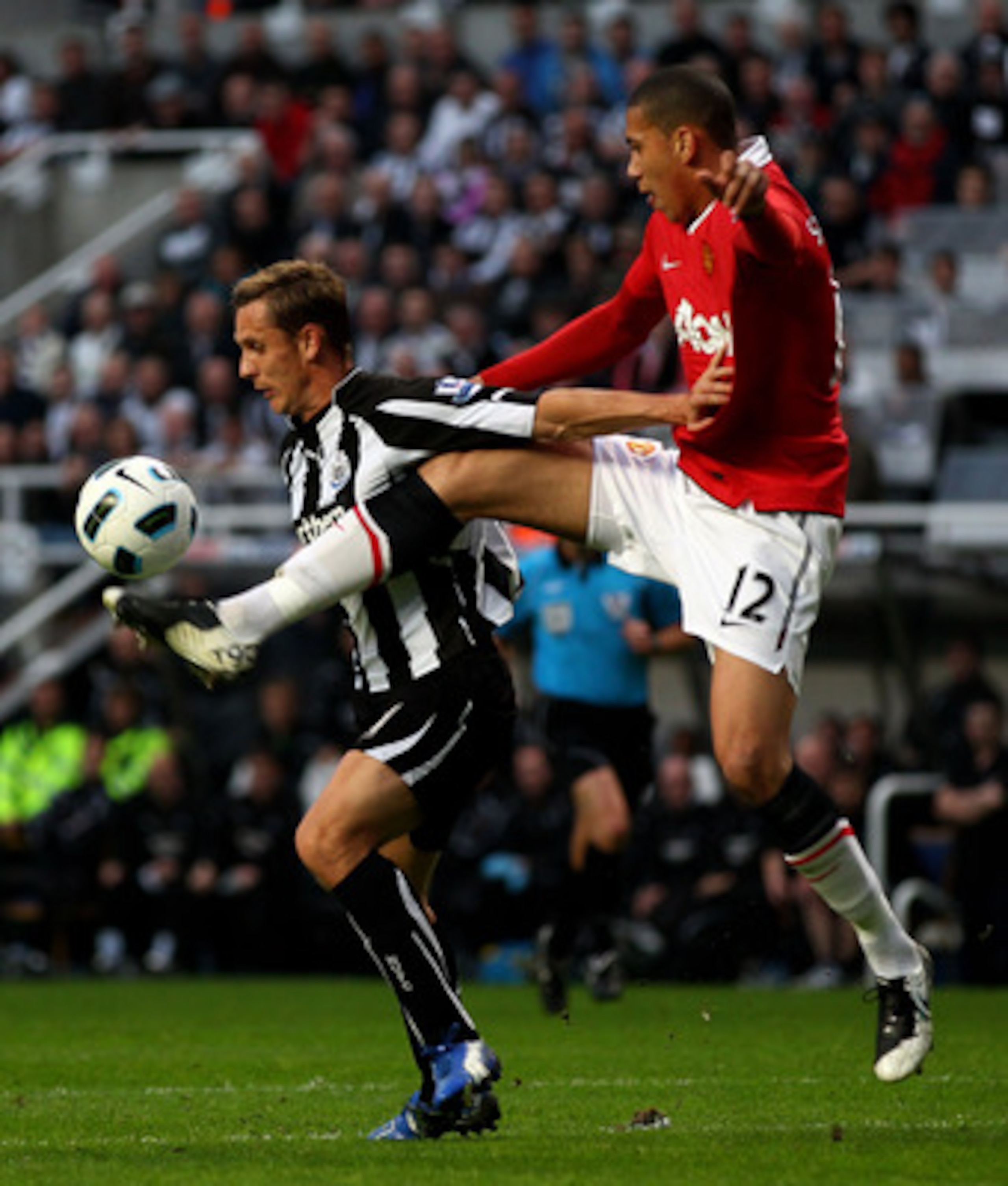 NEWCASTLE, UNITED KINGDOM - APRIL 19:  Peter Lovenkrands of Newcastle United is challenged by Chris Smalling of Manchester United during the Barclays Premier League match between Newcastle United and Manchester United at St James' Park on April 19, 2011 i